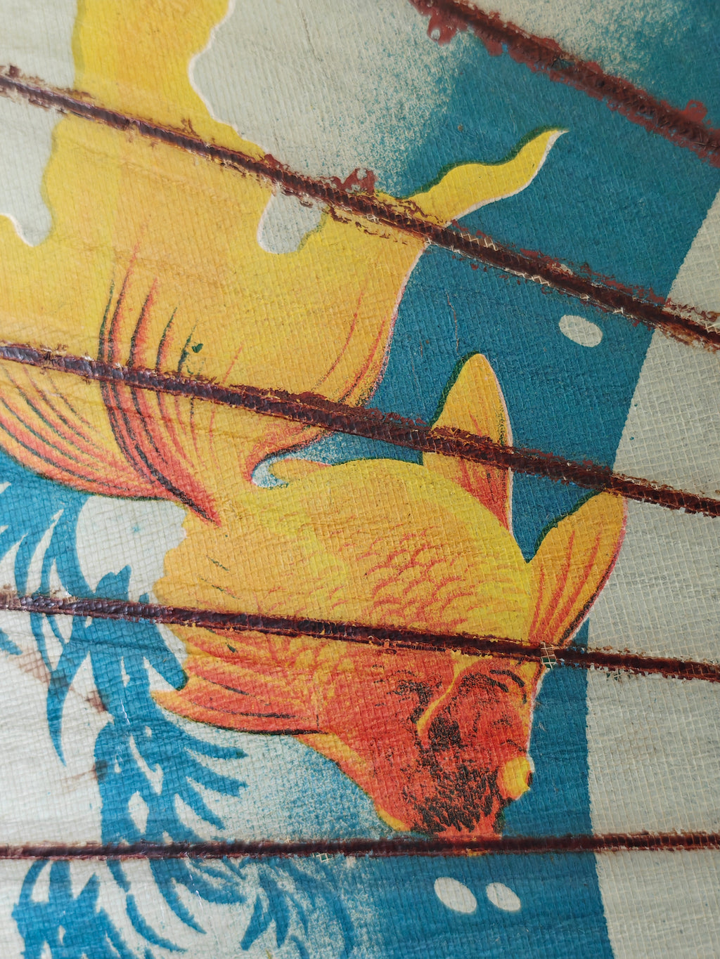Close-up of a decorative wood and paper Chinese parasol with gold fish pattern