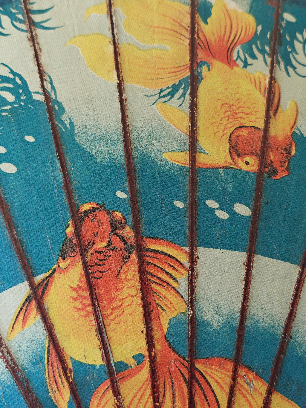 Close-up f a decorative wood and paper Chinese parasol with gold fish pattern