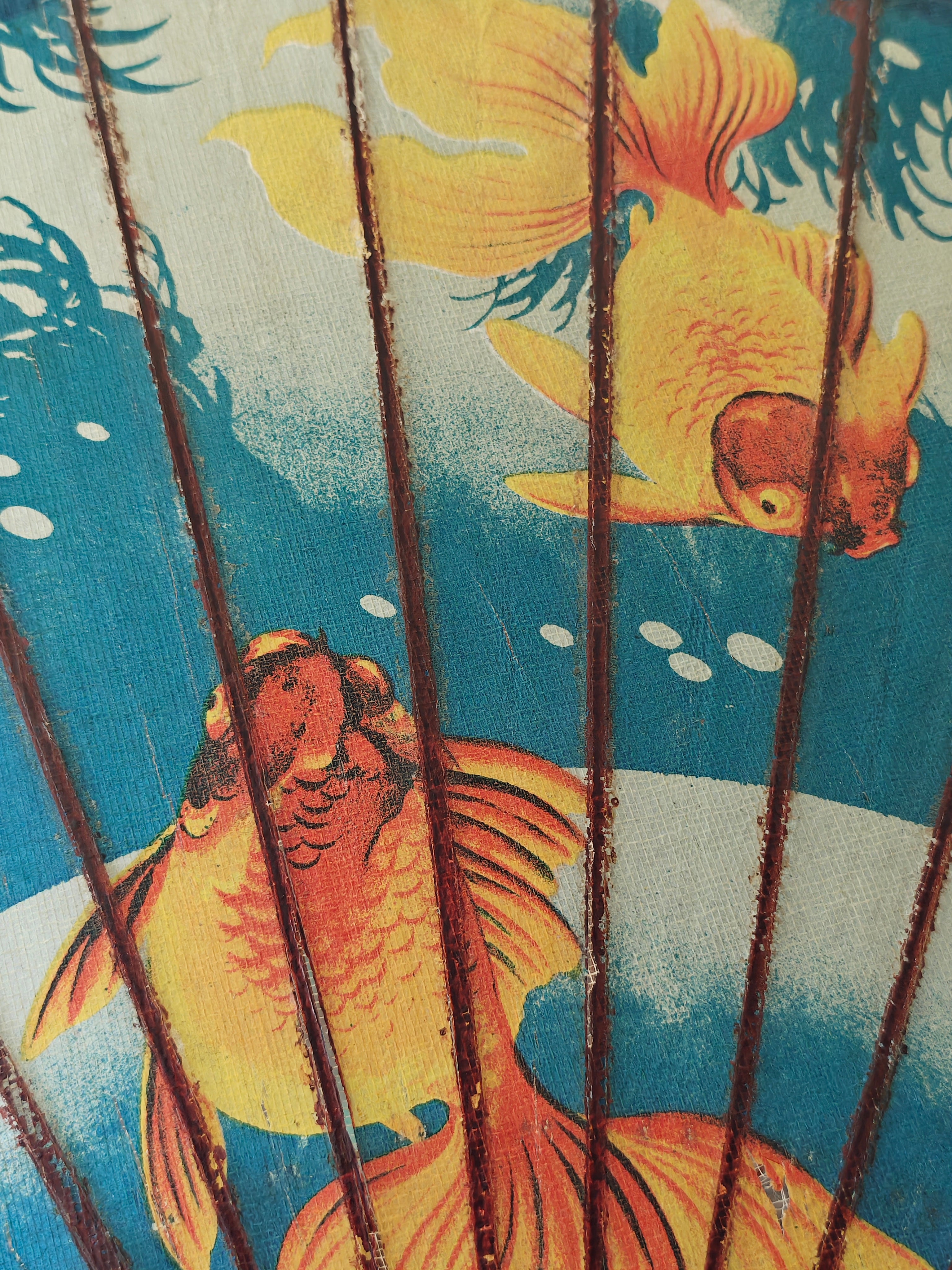 Close-up f a decorative wood and paper Chinese parasol with gold fish pattern