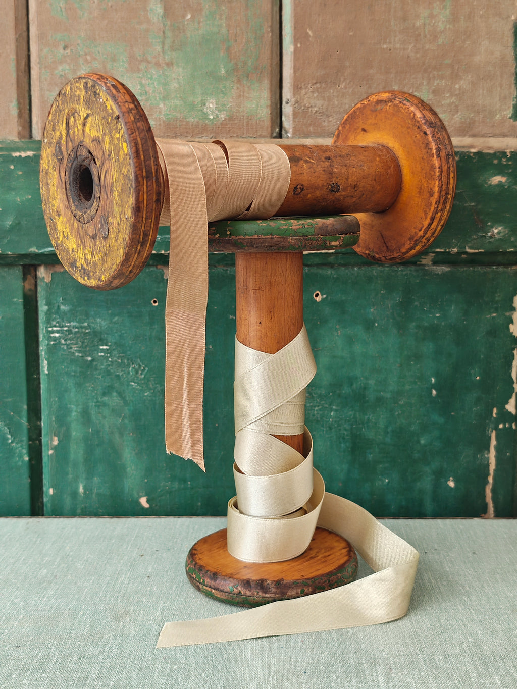 Two vintage wooden spools with traces of paint