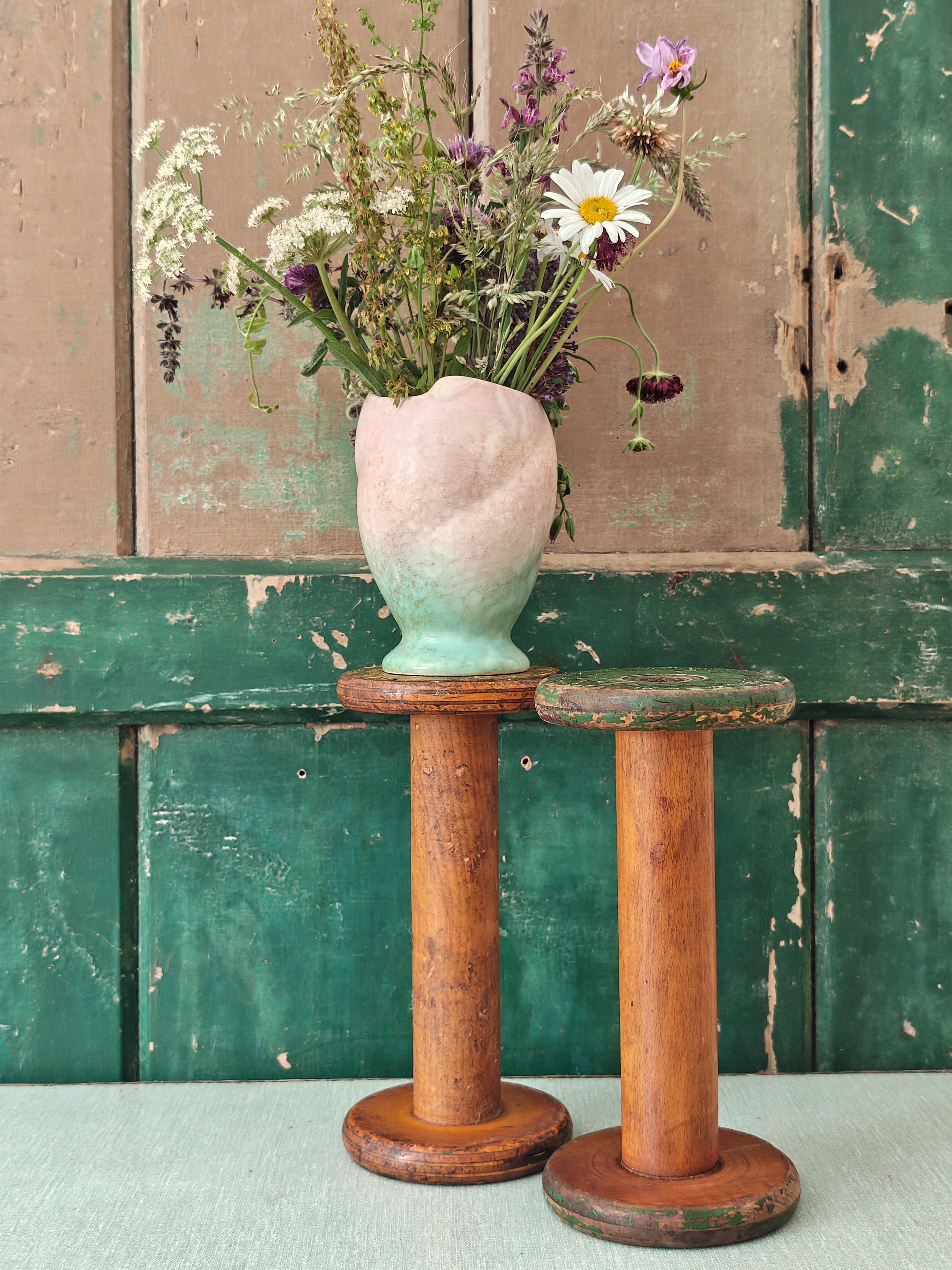 Two vintage wooden spools with traces of paint