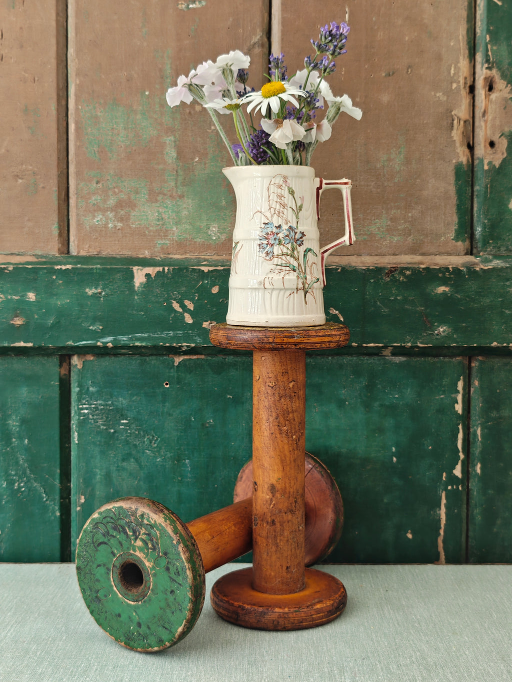 Two vintage wooden spools with traces of paint