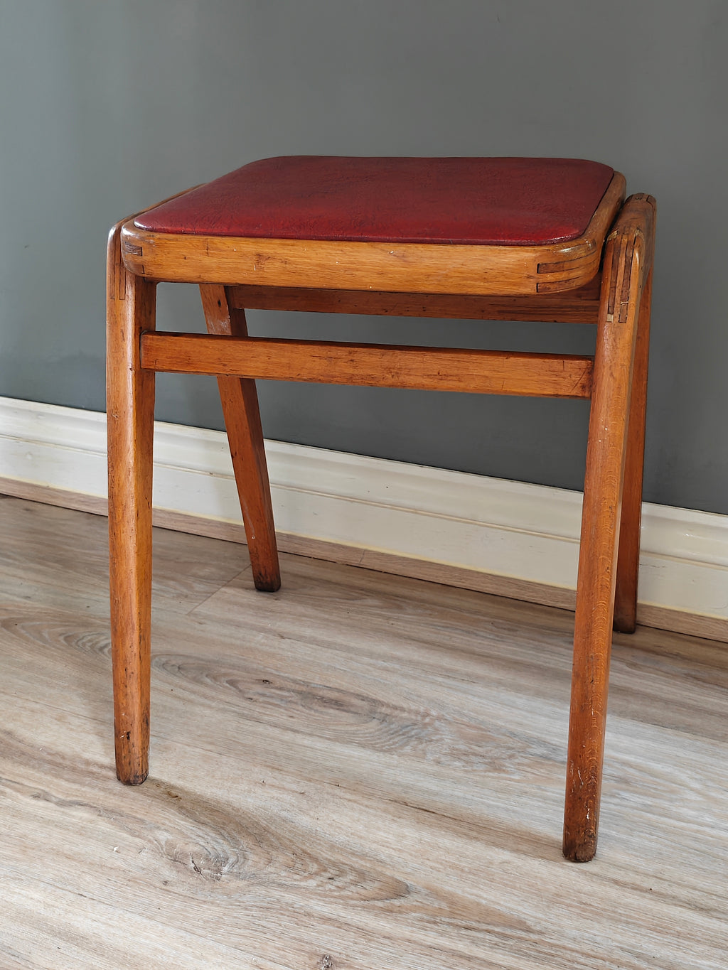 Mid-century wood frame stool with red vinyl seat