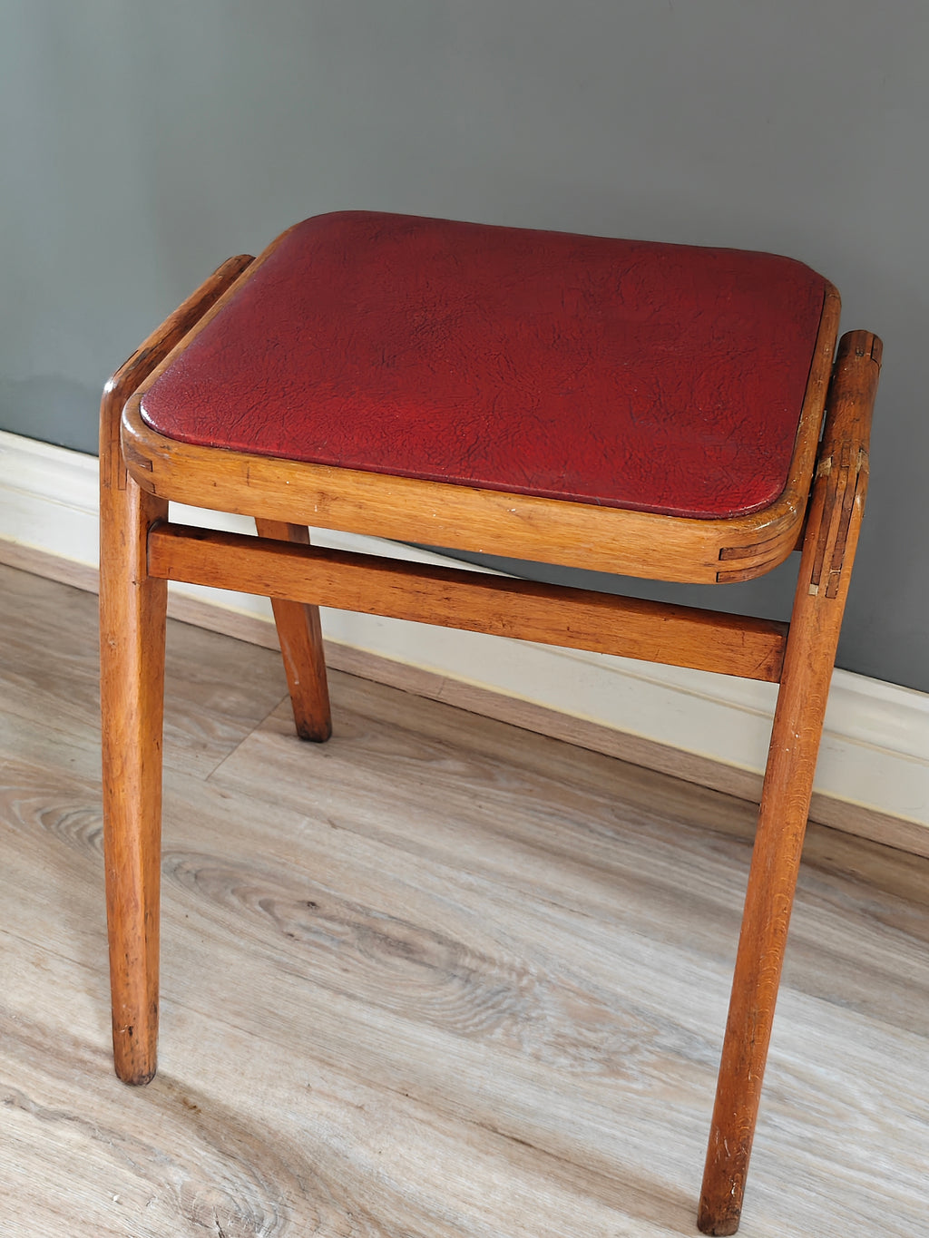 Mid-century wood frame stool with red vinyl seat