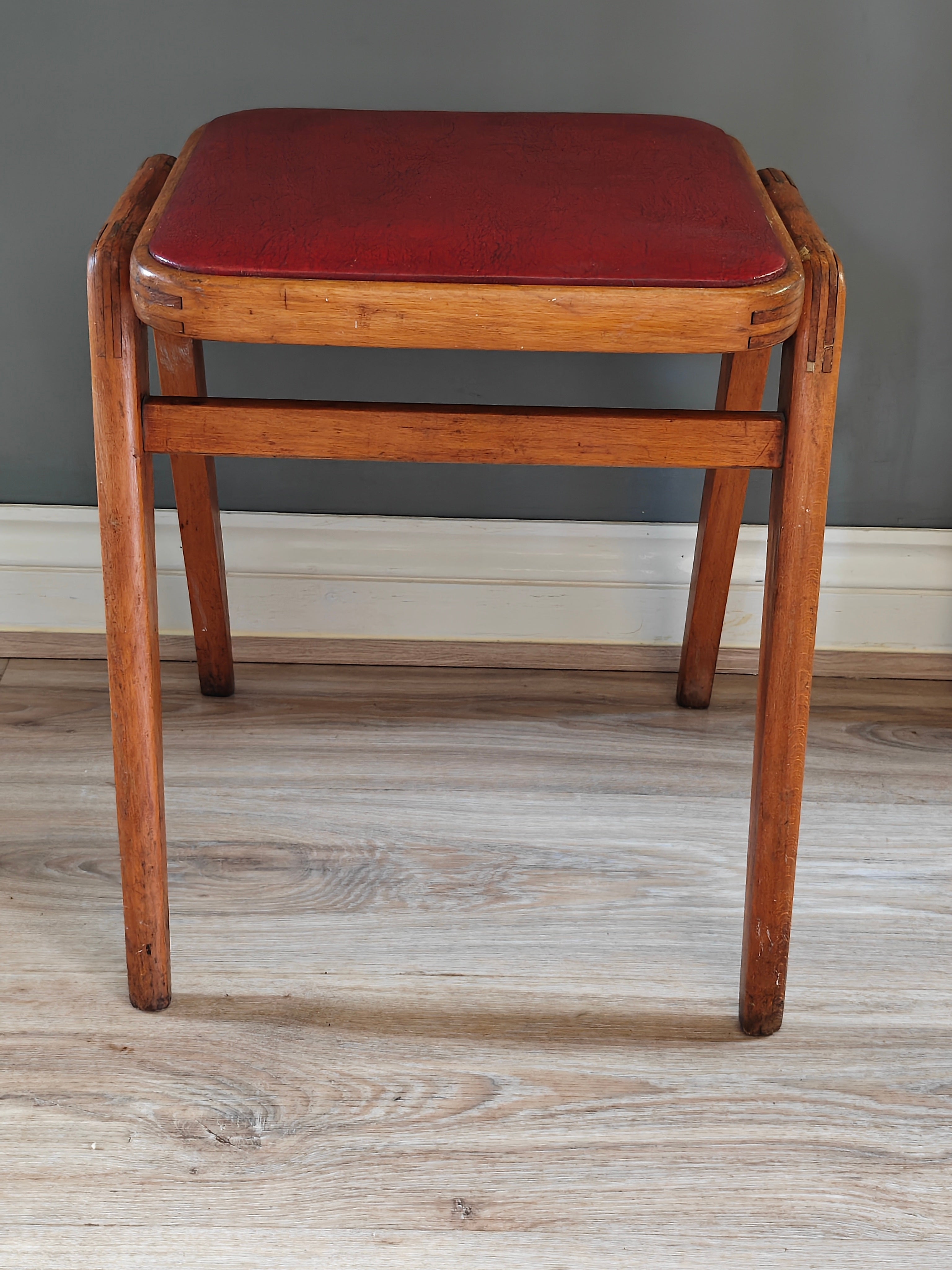 Mid-century wood frame stool with red vinyl seat