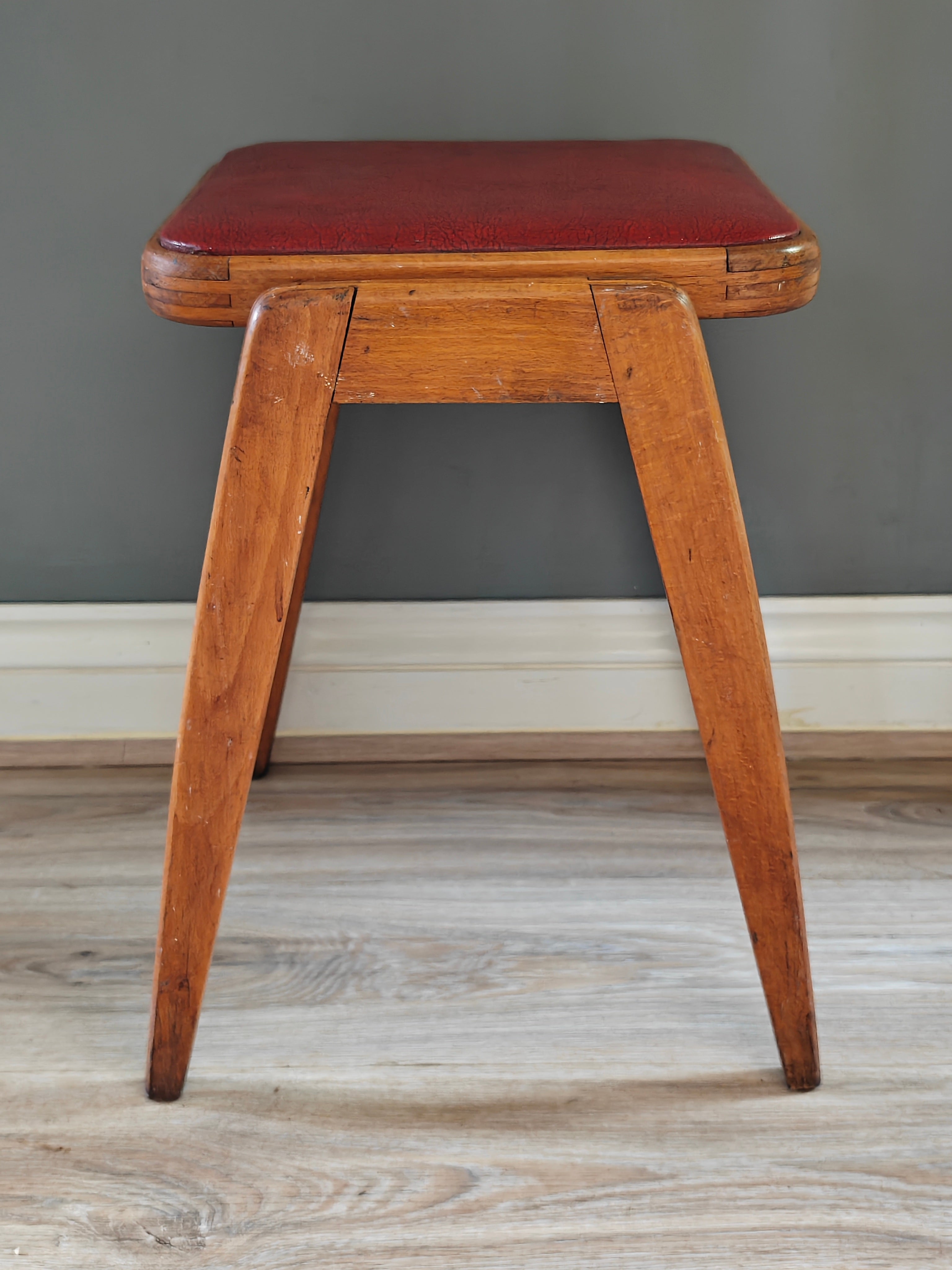 Mid-century wood frame stool with red vinyl seat