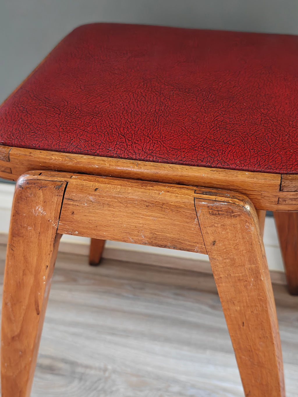 Mid-century wood frame stool with red vinyl seat