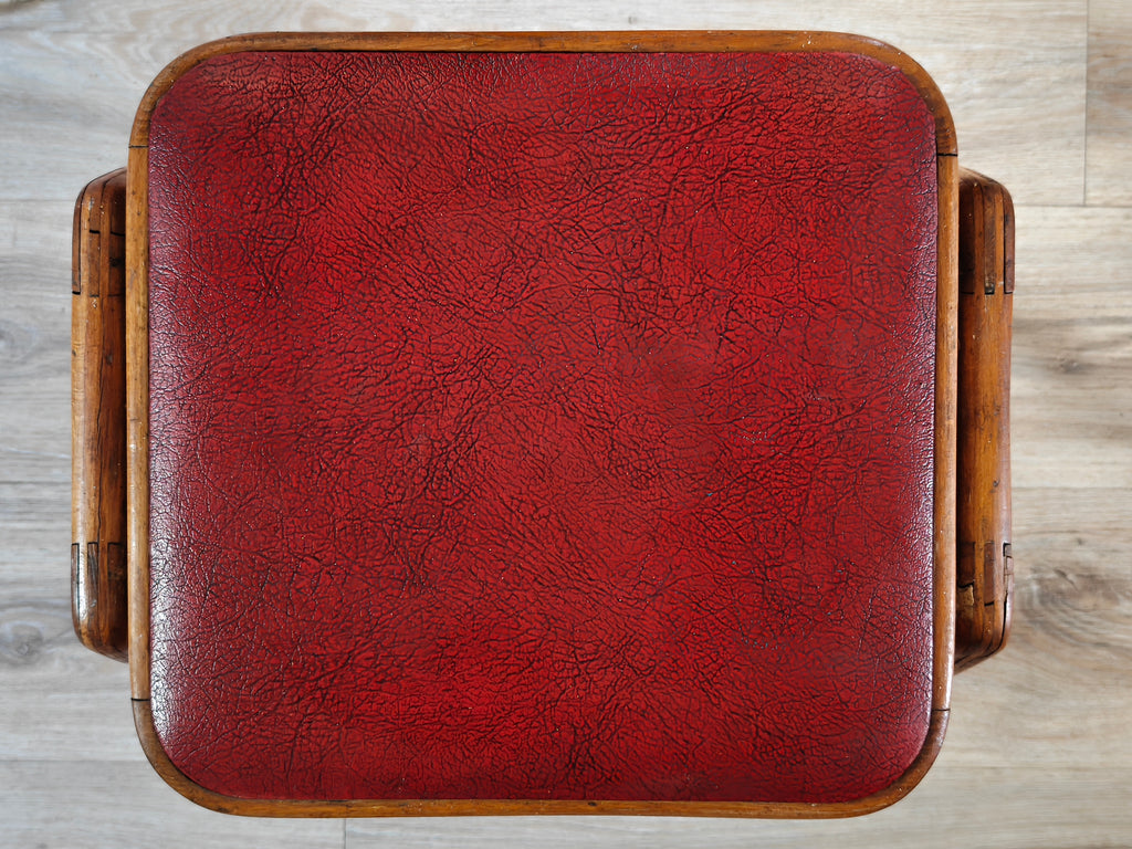 Top view of the seat of a stool with red vinyl cover