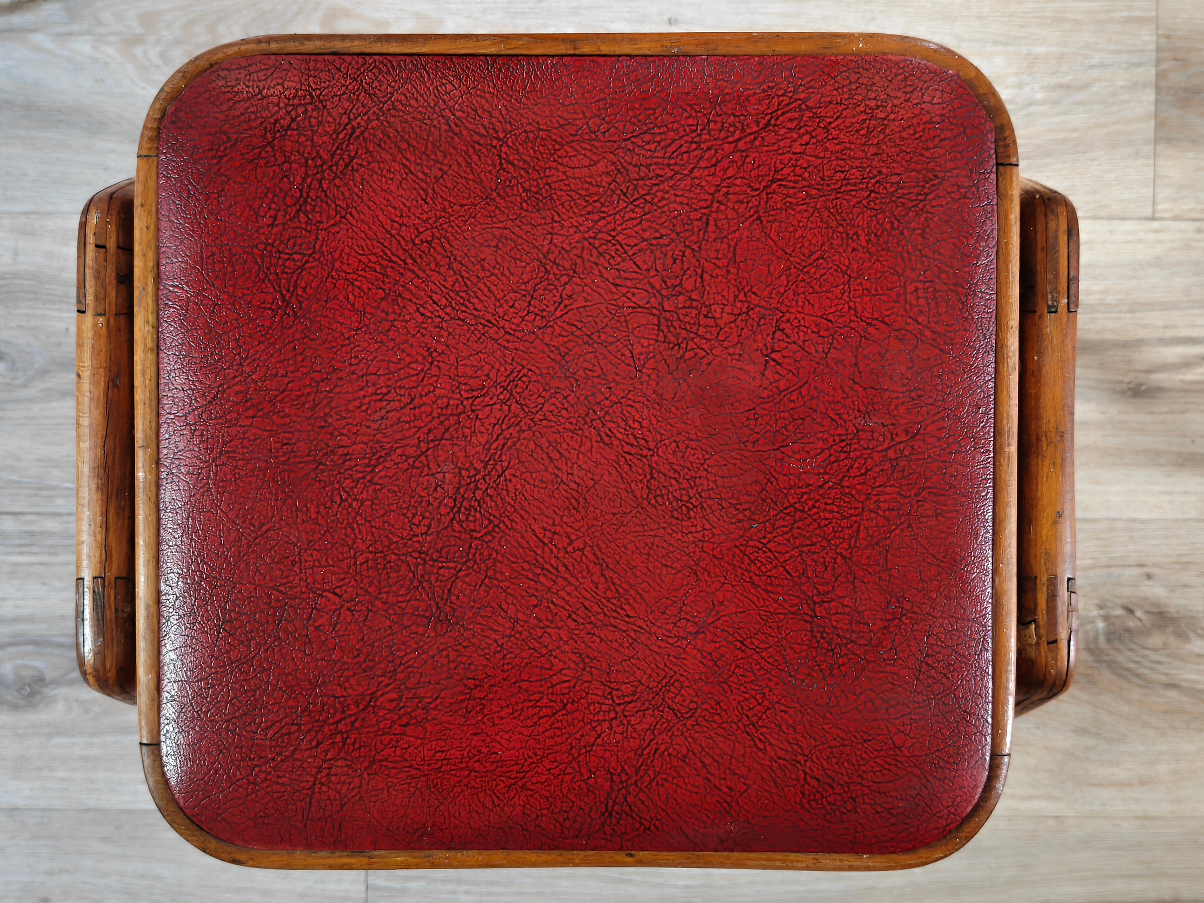 Top view of the seat of a stool with red vinyl cover