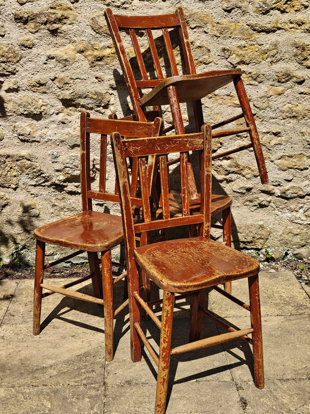 Four rustic wooden dining chairs with a distressed finish