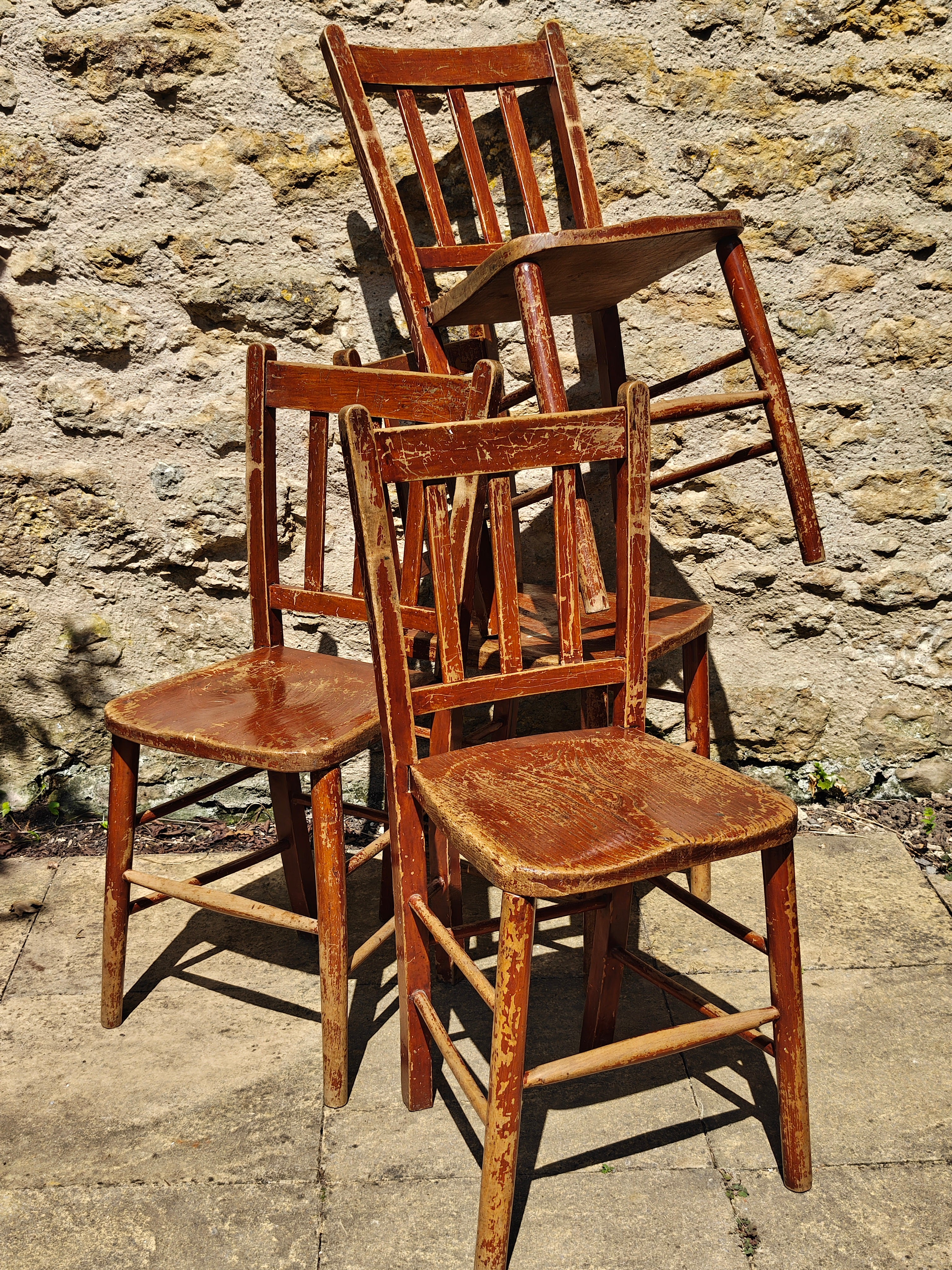 Four rustic wooden dining chairs with a distressed finish