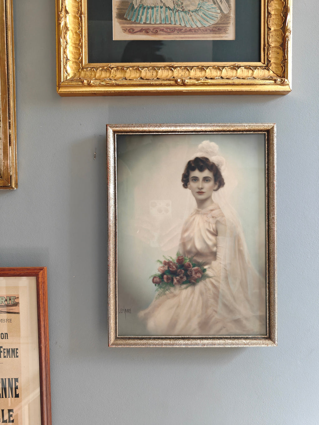 A framed vintage-style portrait print of a woman in a white wedding dress holding flowers.