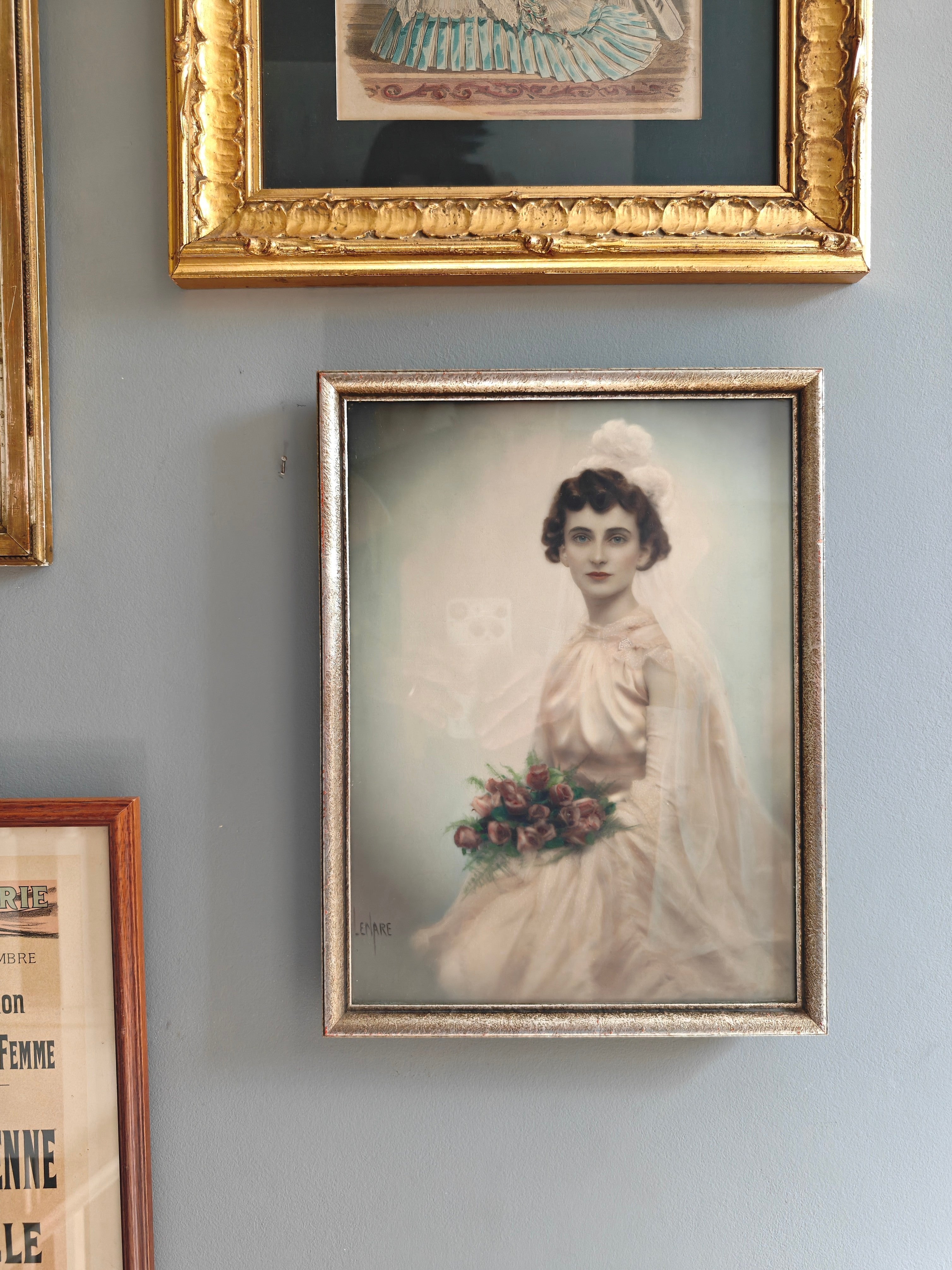 A framed vintage-style portrait print of a woman in a white wedding dress holding flowers.