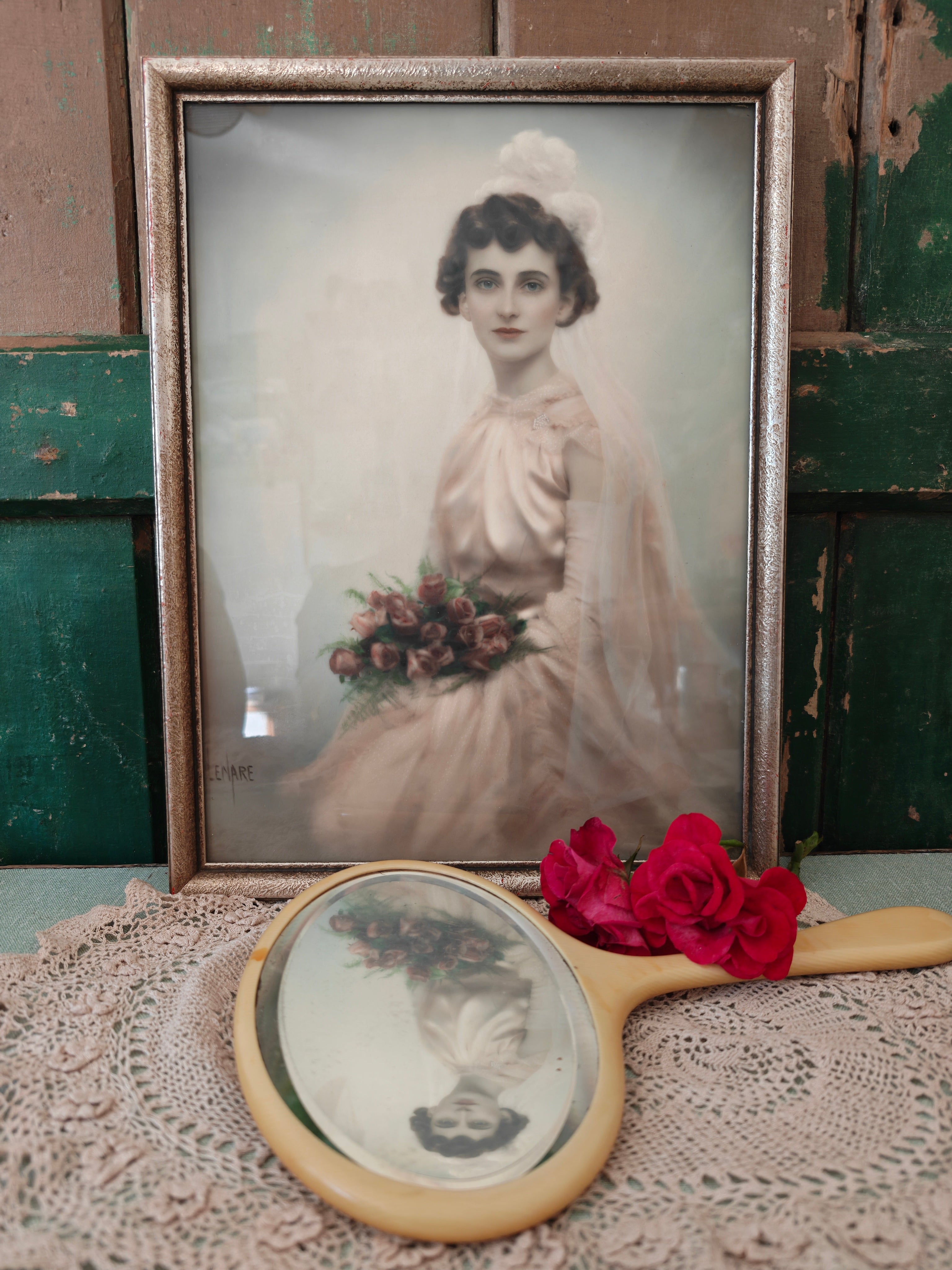A vintage framed portrait print of a woman in a white bridal gown holding a bouquet of pink and red flowers, set in an ornate gold-toned frame.