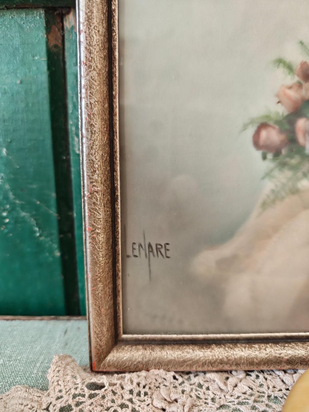 A close-up of a vintage framed art print with a distressed gold frame, featuring a signature 'LENARE' on the lower left and a floral details on the right.