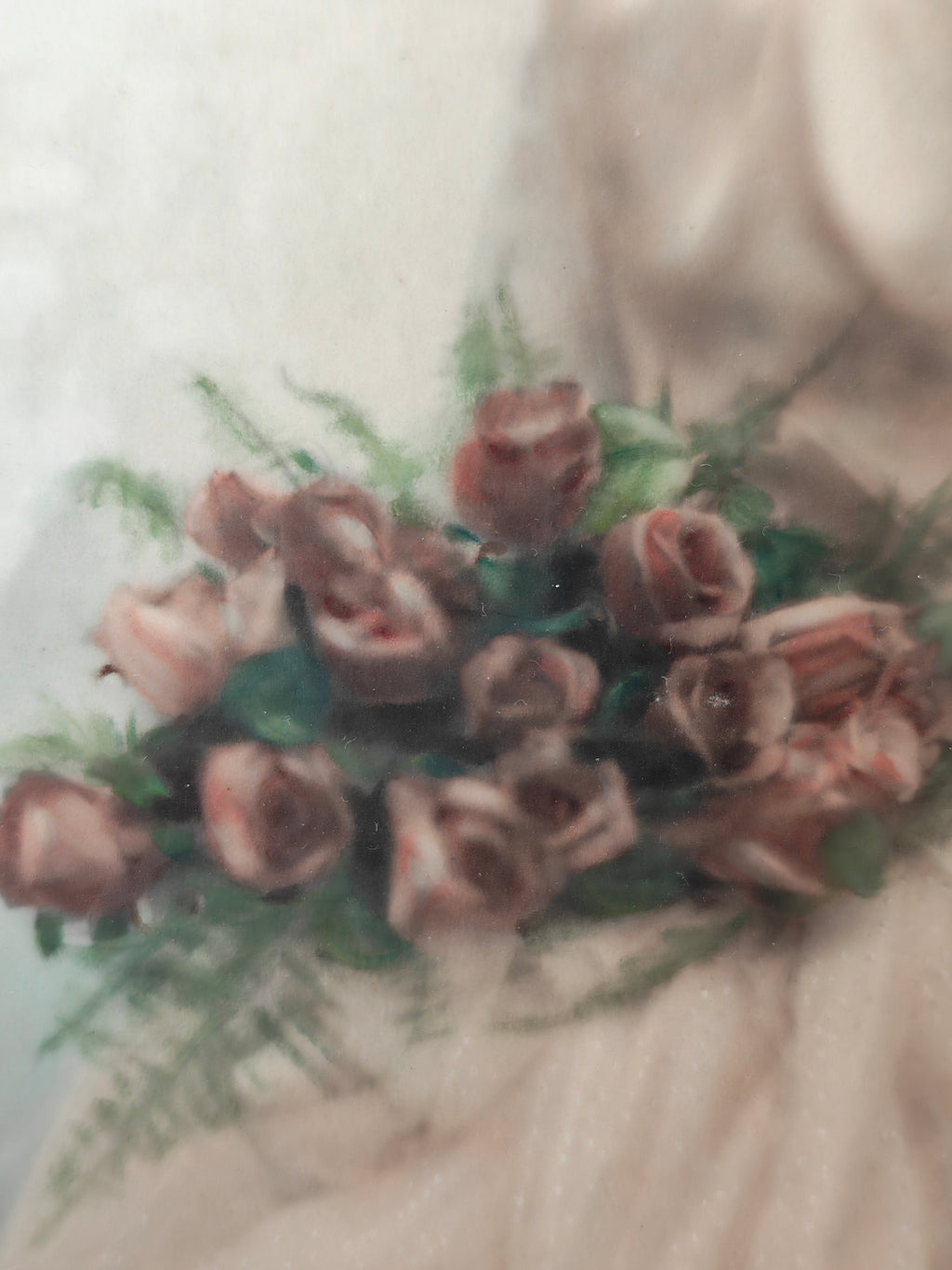 A close-up of a vintage print showing a bouquet of roses in muted dusty pink and brown tones with green foliage.