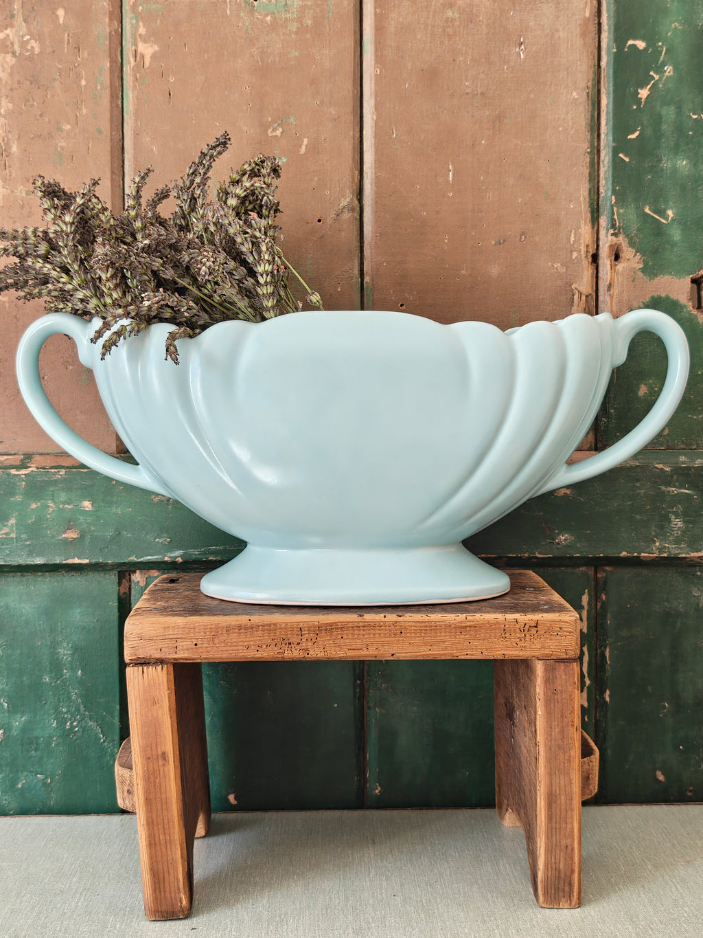 A large pale blue mantle vase with fluted form and two handles