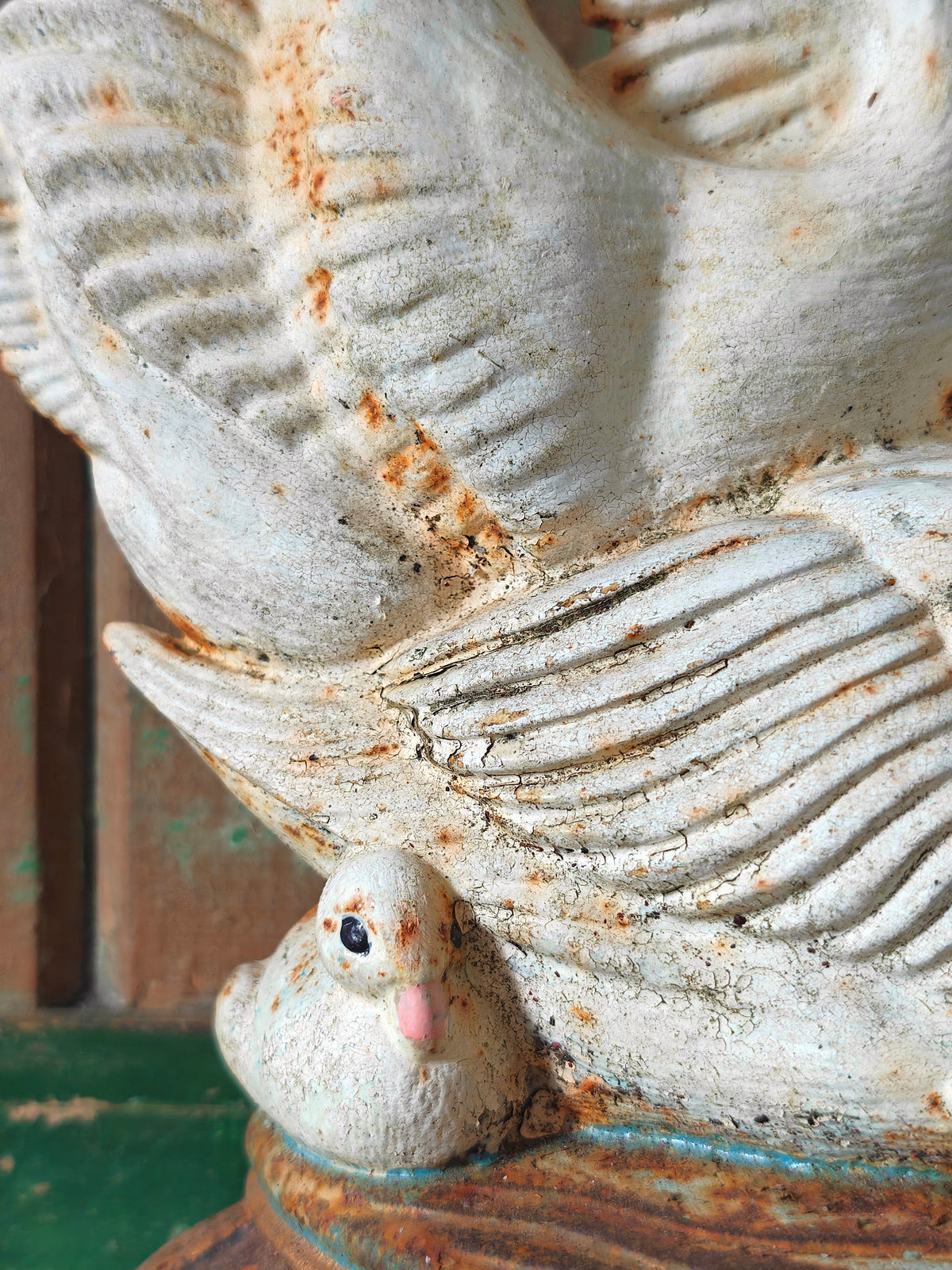 Close up of a swan cygnet with swan wing above as part of a cast iron model