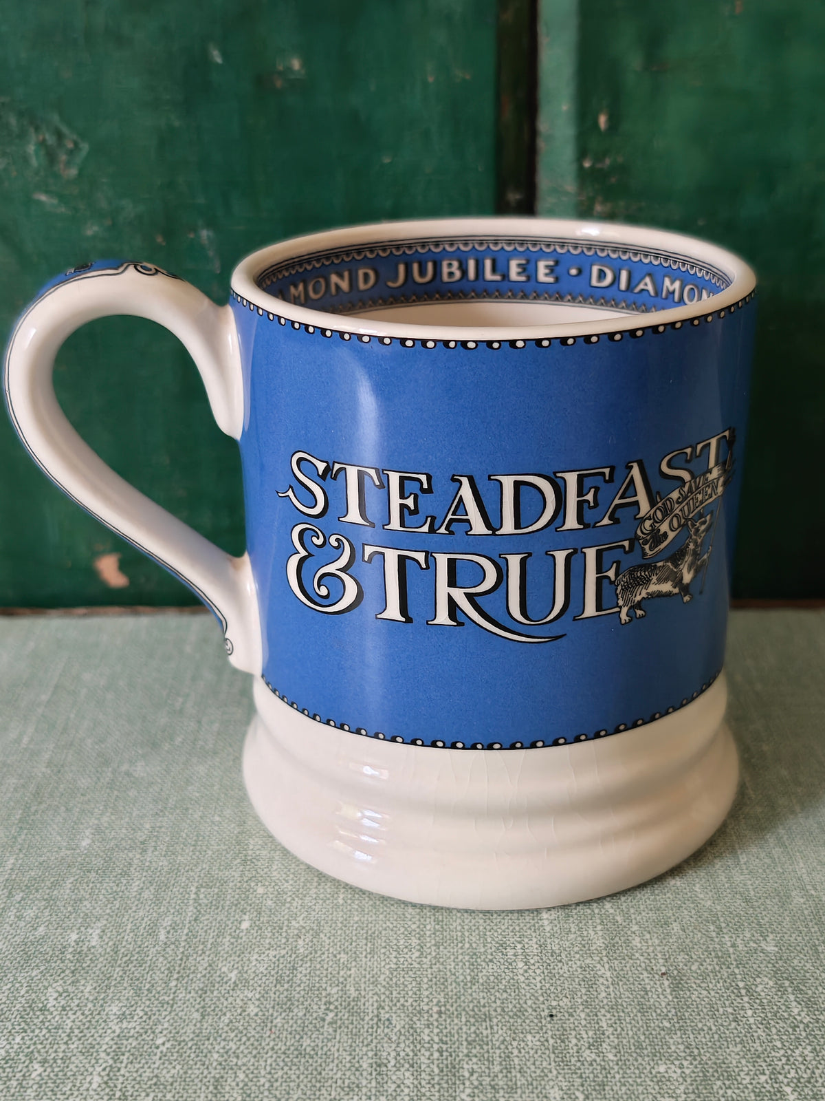 A ceramic mug with a blue and white design, featuring the text 'STEADFAST & TRUE'.