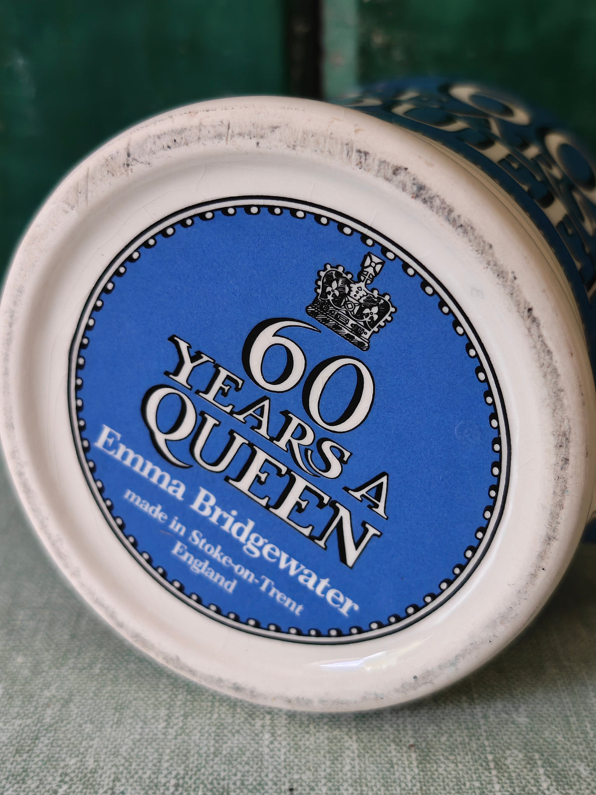 Bottom view of a ceramic mug with the words 60 Years a Queen and the makers mark Emma Bridgewater