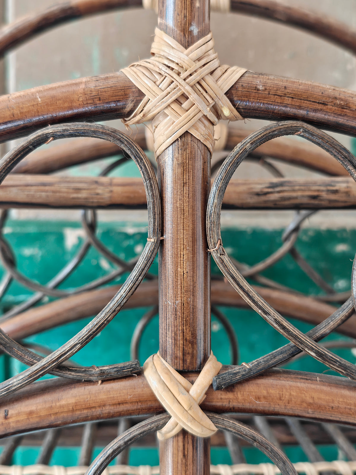 Close up of a vintage bamboo and rattan magazine rack with a rounded dome shape, featuring brown wooden frame and woven bamboo accents.