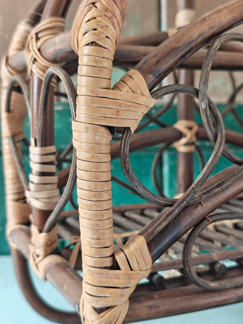 Close-up of a vintage bamboo and rattan magazine rack with a rounded dome shape, featuring brown wooden frame and woven bamboo accents.