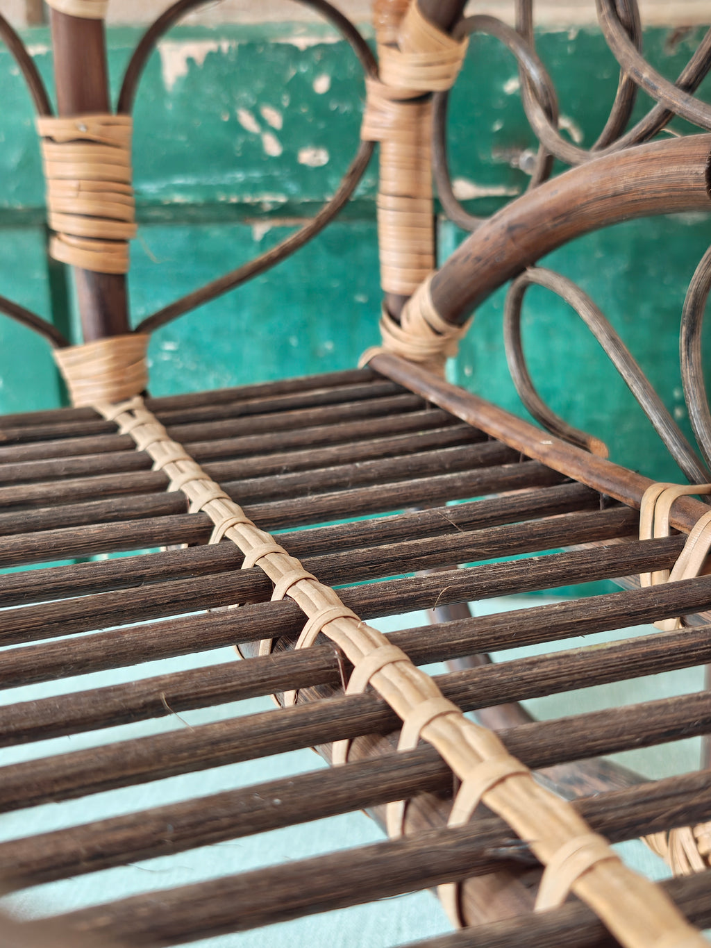 Close-up of a vintage bamboo and rattan magazine rack with a rounded dome shape, featuring brown wooden frame and woven bamboo accents.