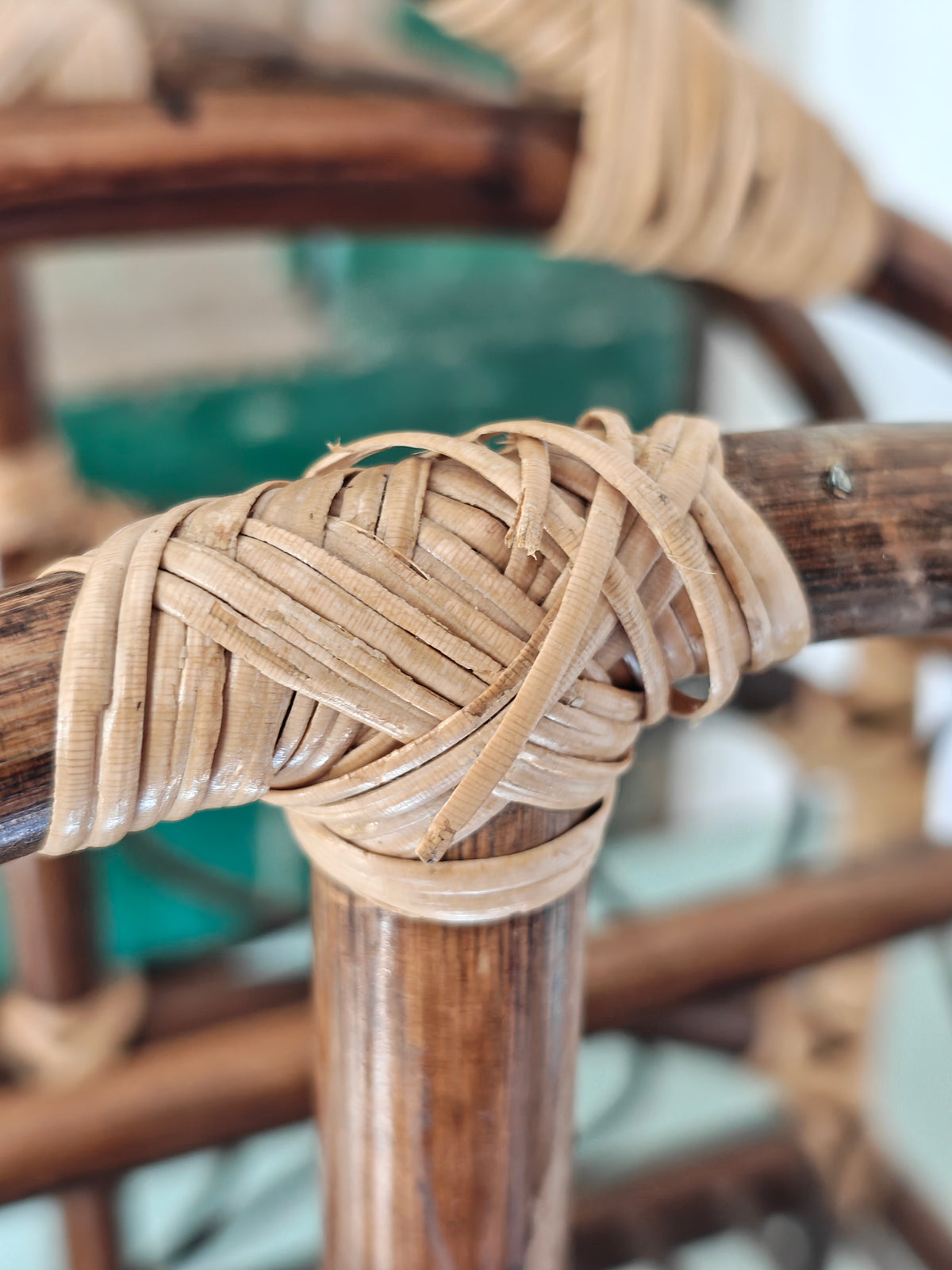 Close-up of a vintage bamboo and rattan magazine rack with a rounded dome shape, featuring brown wooden frame and woven bamboo accents.