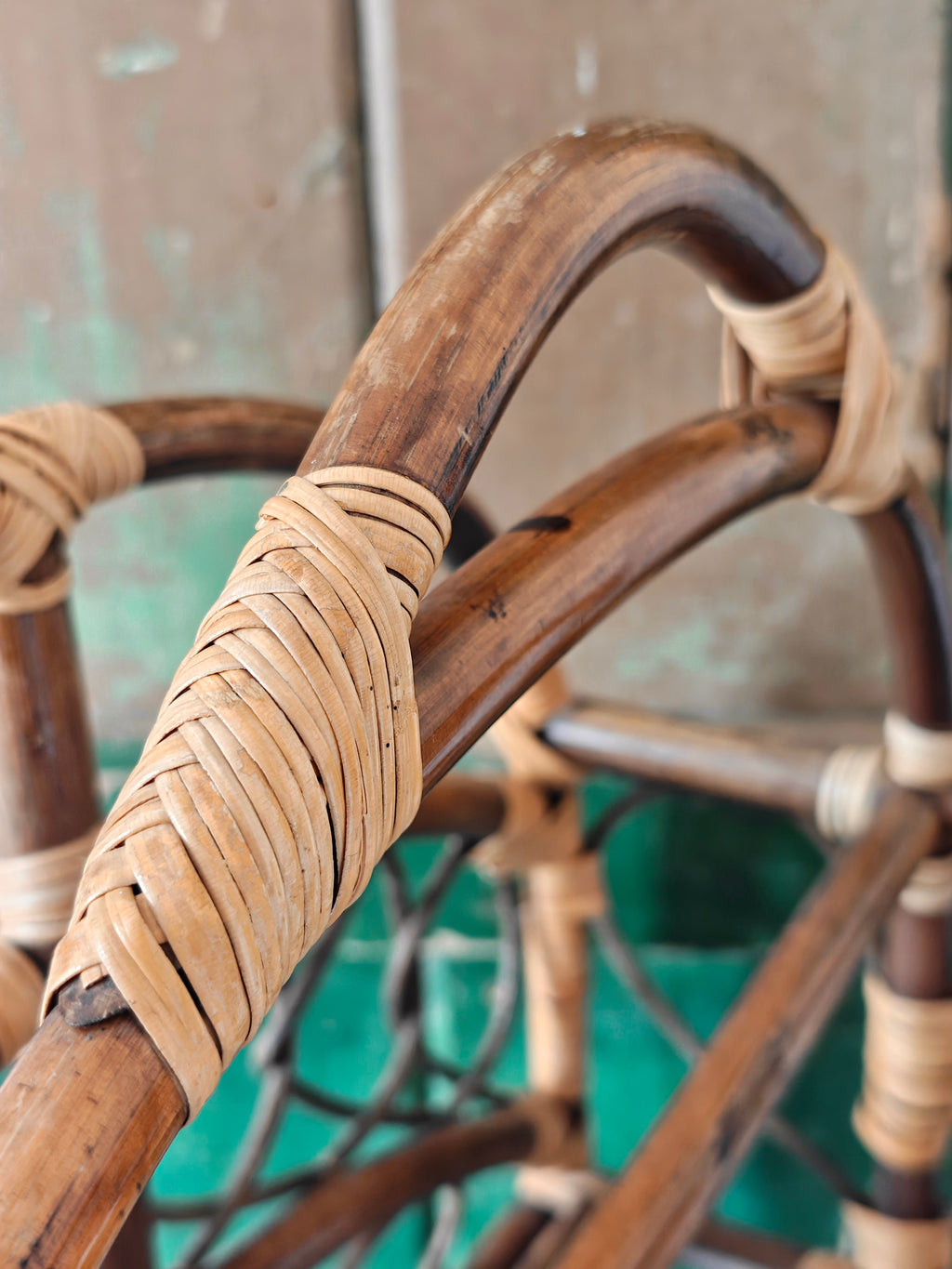Close-up of a vintage bamboo and rattan magazine rack with a rounded dome shape, featuring brown wooden frame and woven bamboo accents.
