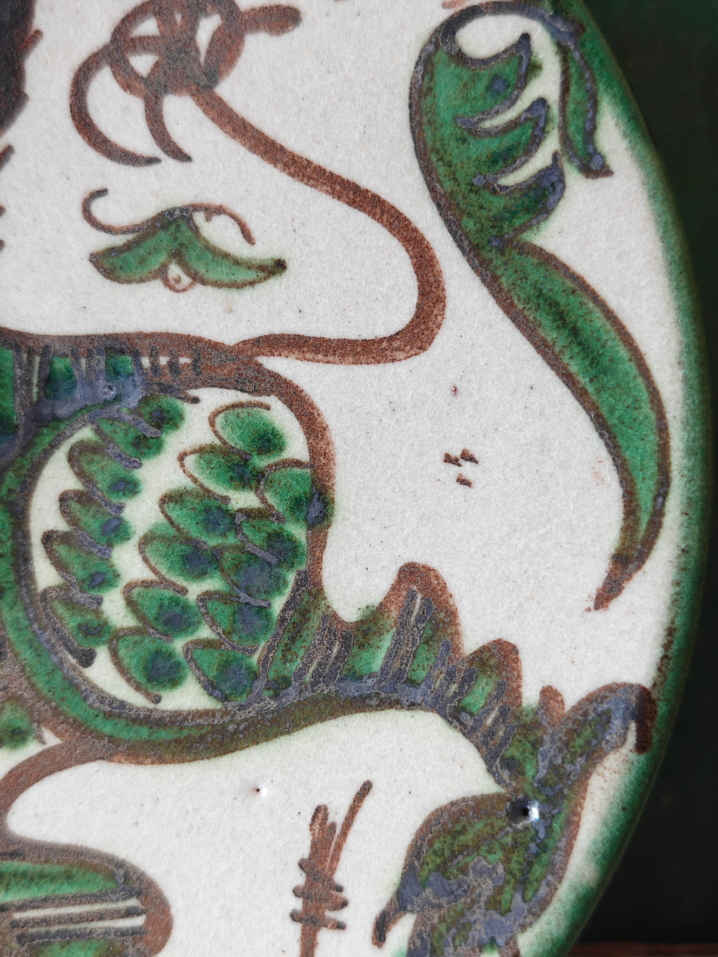 Close up of the hand painted decoration on a ceramic plate