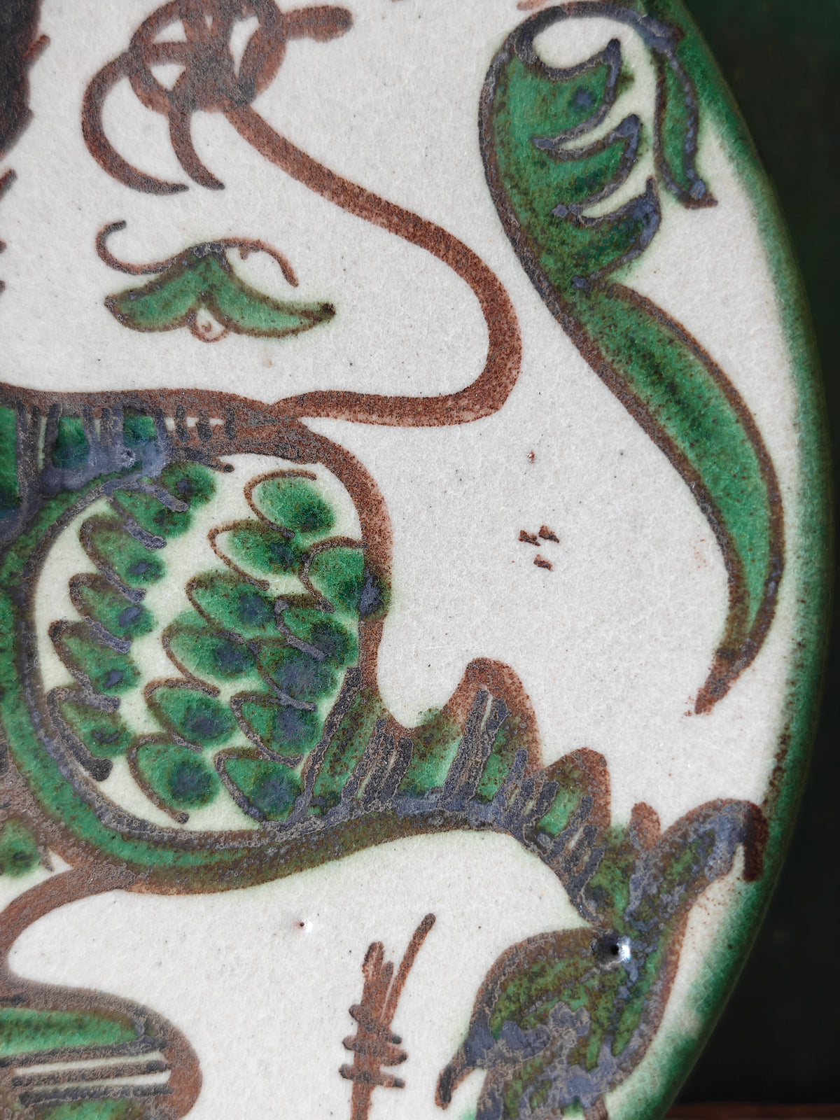 Close up of the hand painted decoration on a ceramic plate