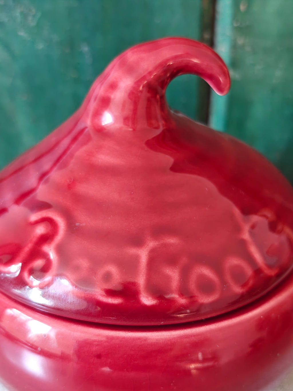 A close-up of a glossy red ceramic pot with a pointed lid and embossed script reading 'Beetroot'.