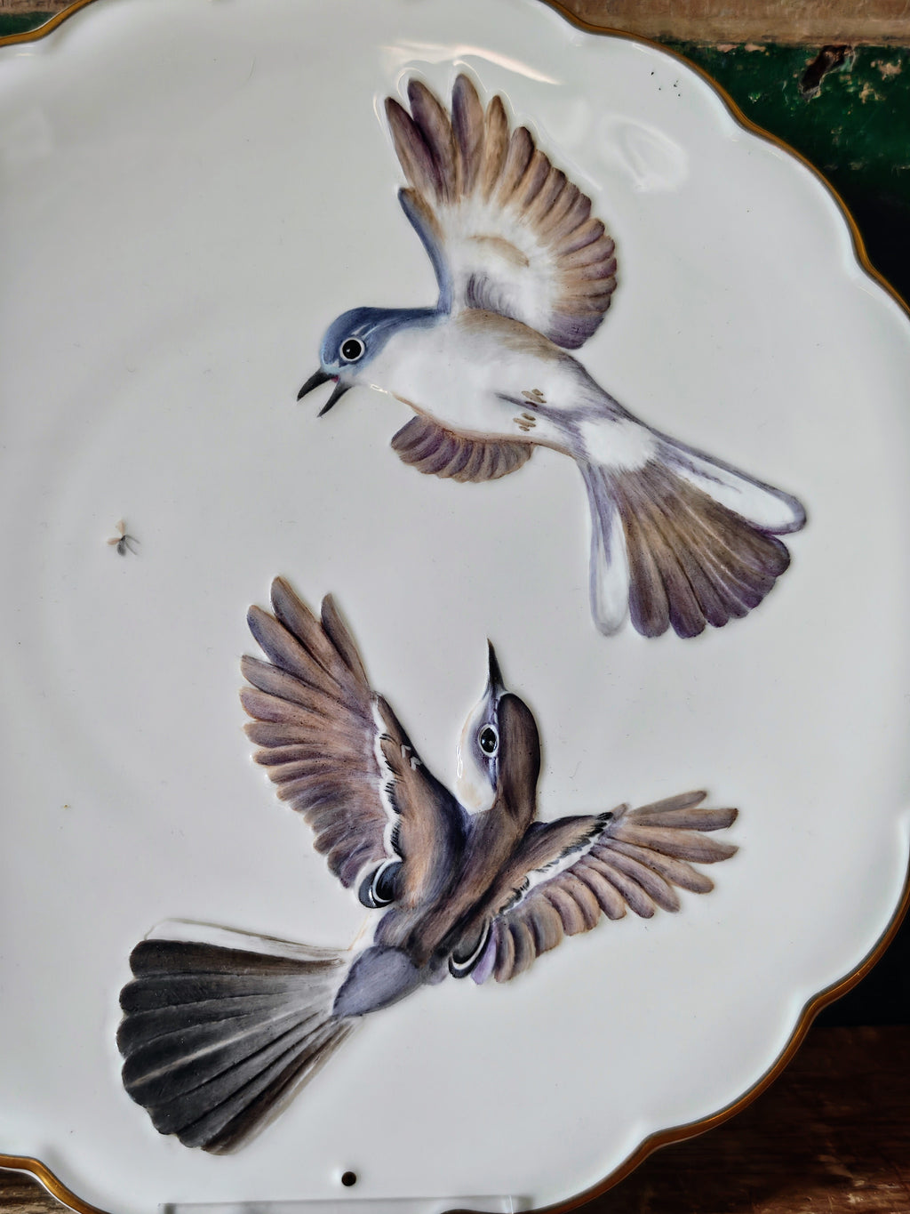 Close-up of decoration of two birds with grey, brown and white feathers on a white plate