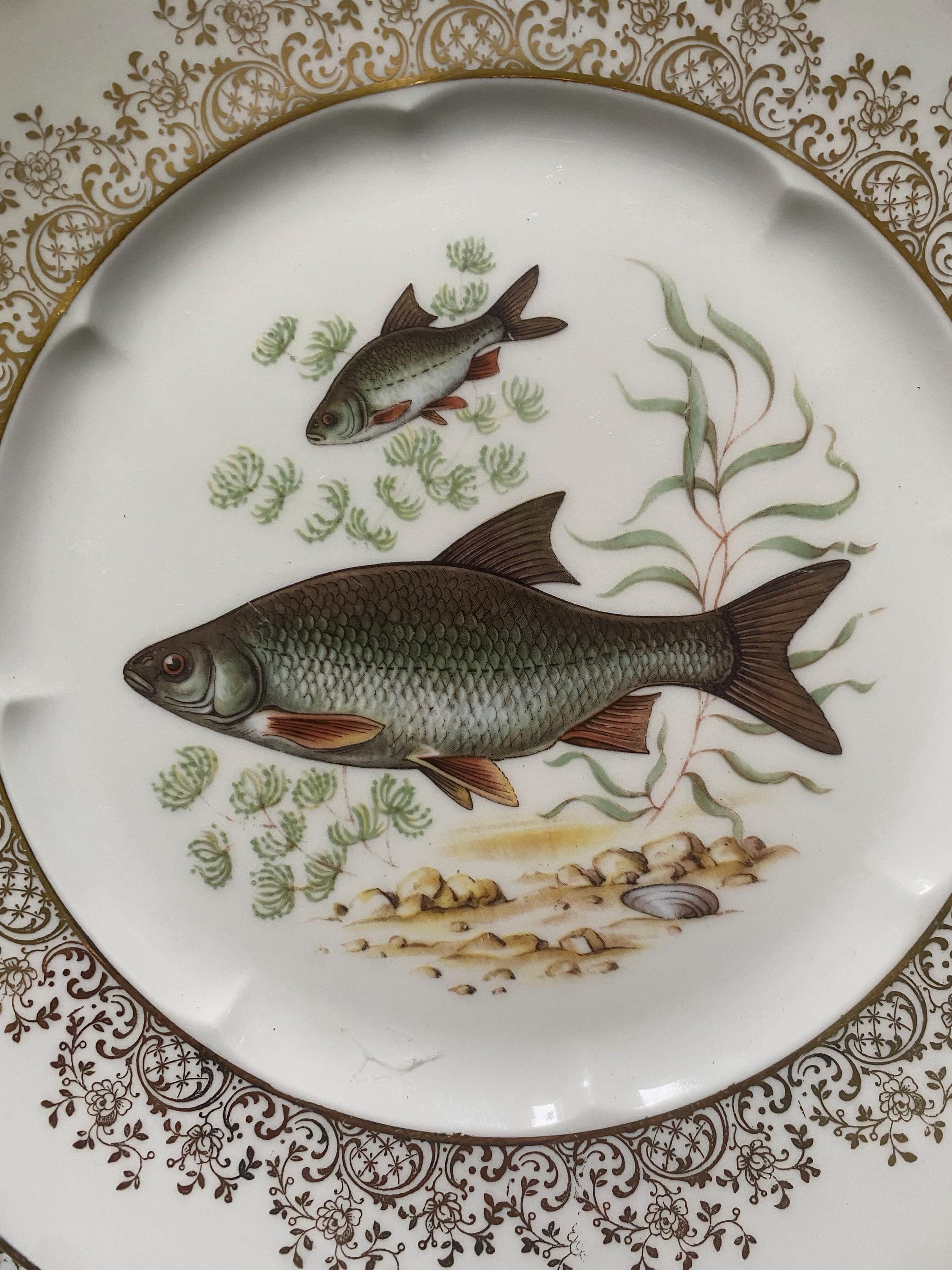 Set of three decorative plates with fish illustrations and gilt decoration