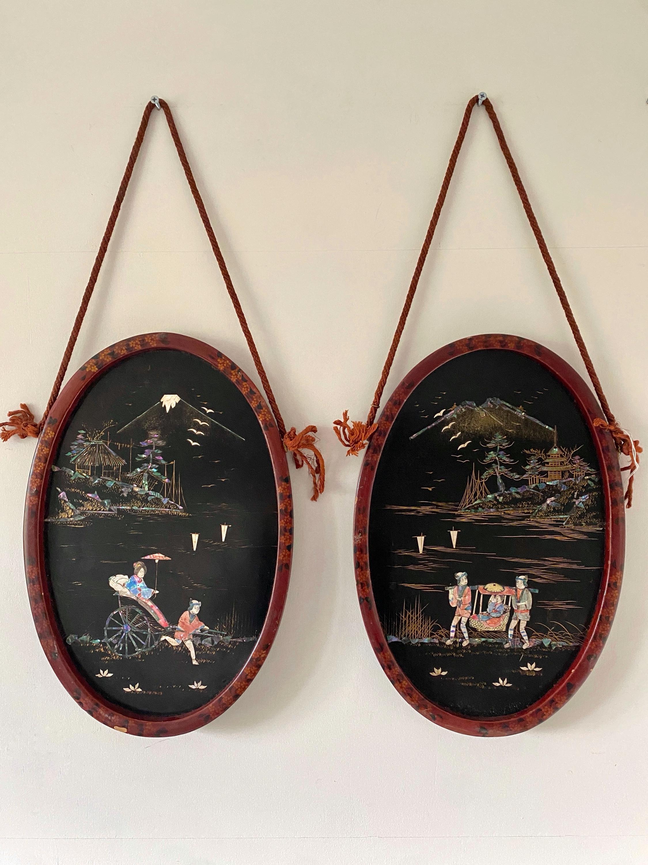 Two oval wall hangings with scenic illustrations on a plain background