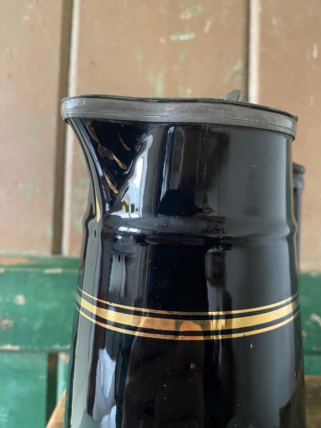 Black ceramic pitcher with gold stripe
