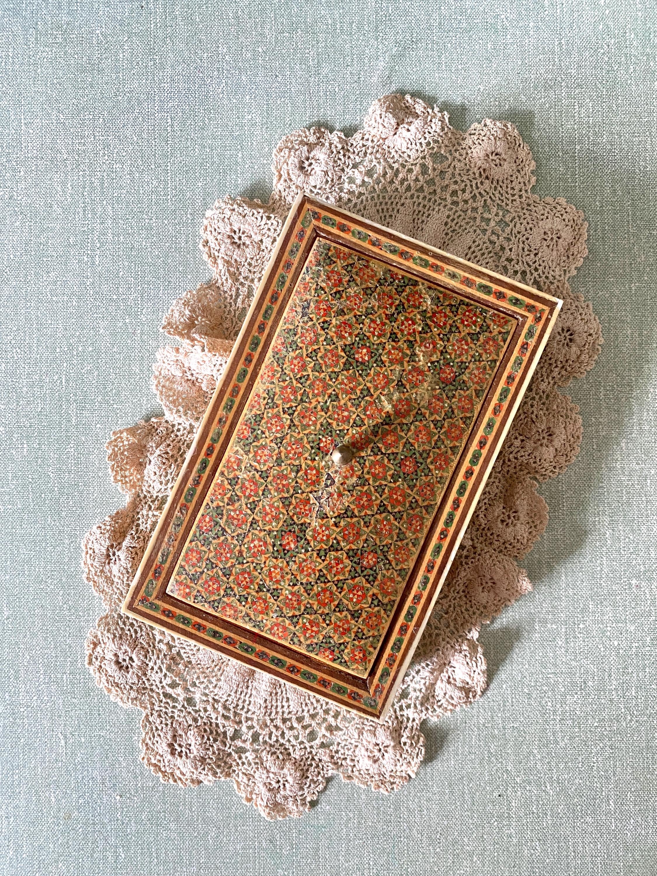 Top of a decorative box with intricate red and green geometric patterns