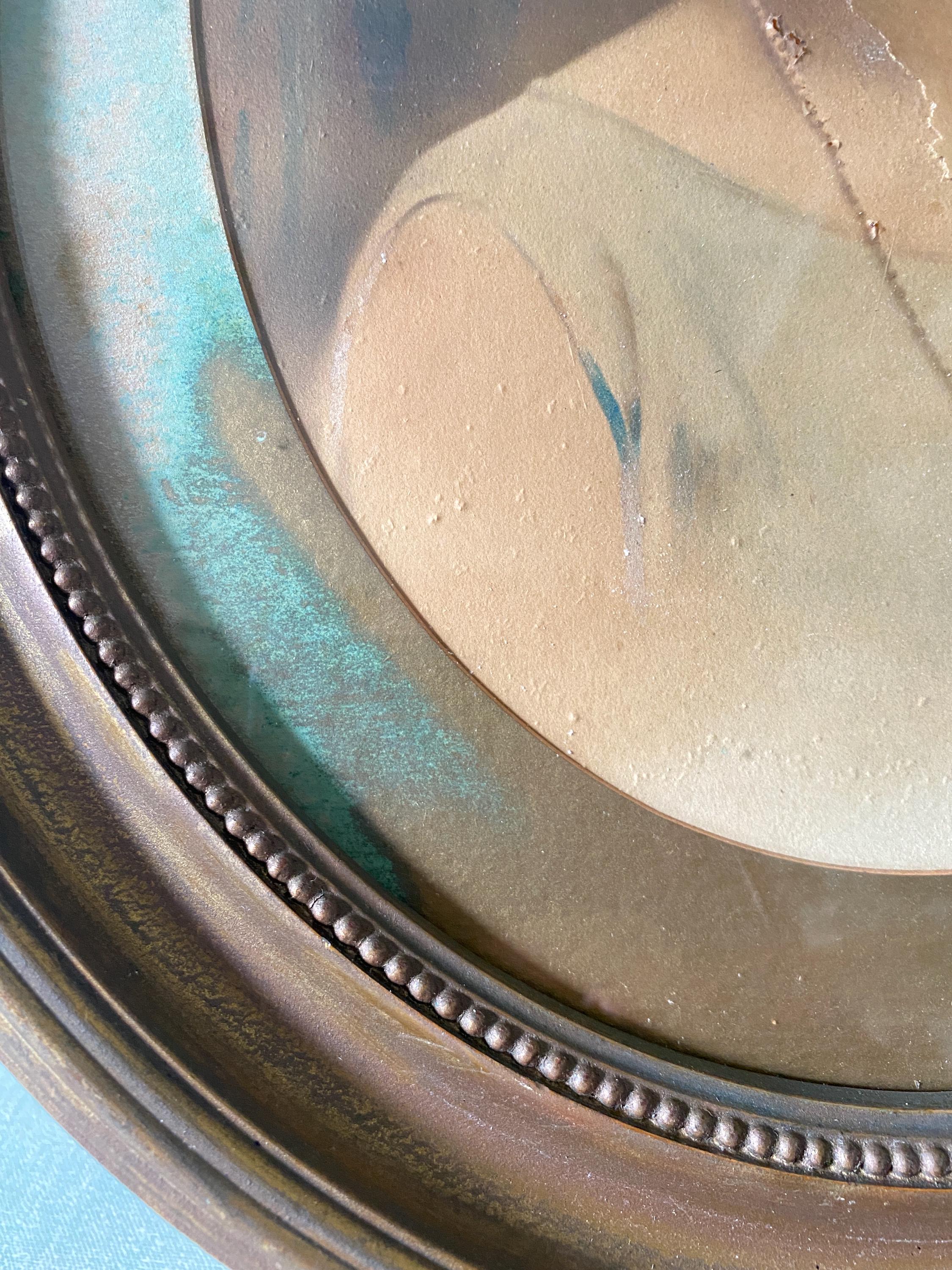 Close-up of part of an oval gold frame and picture mount