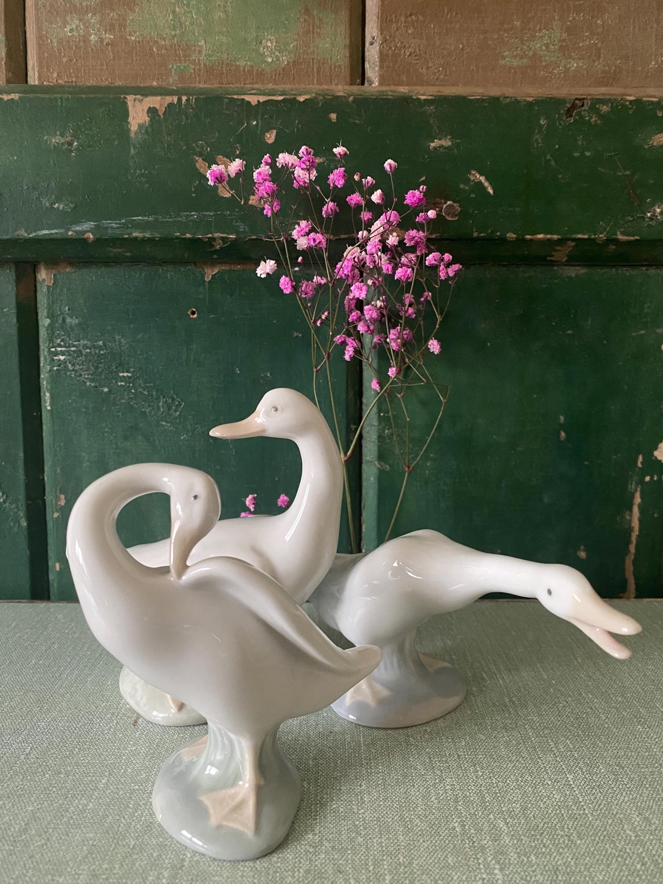 Three white ceramic geese 