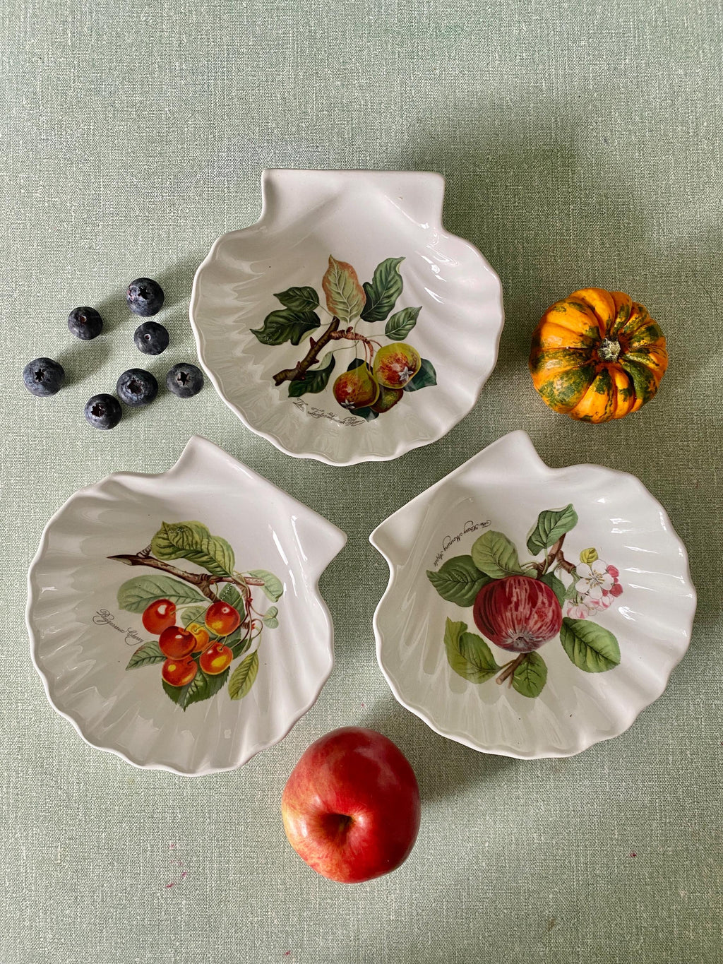 Three decorative ceramic plates with fruit designs