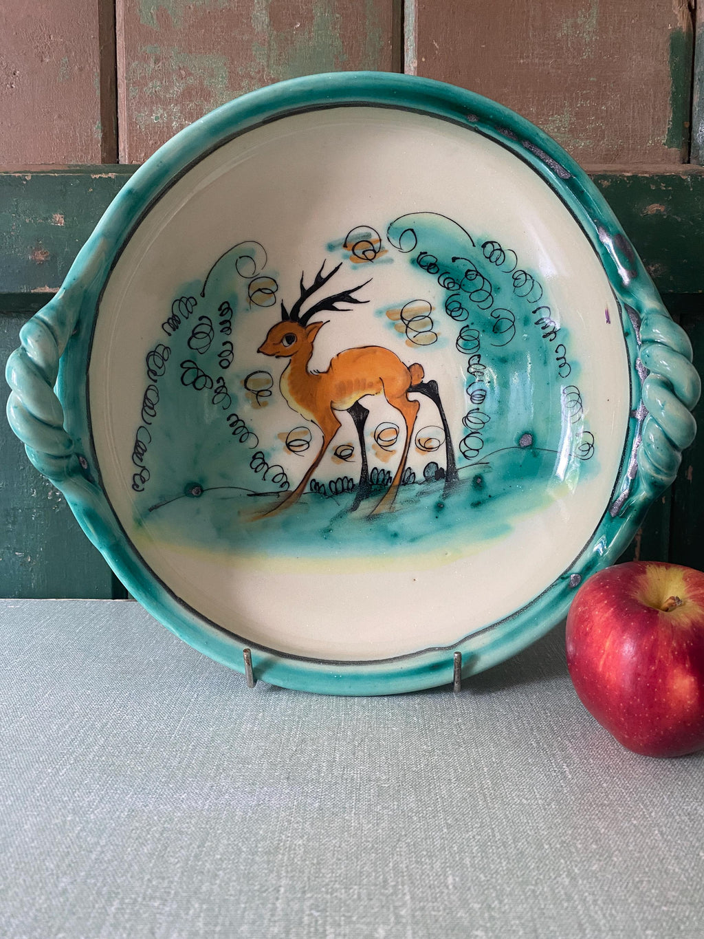 Green and white ceramic bowl with hand painted deer design
