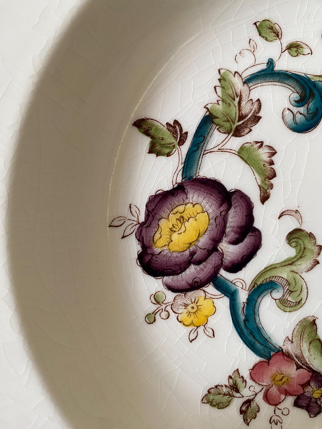 Close-up of a decorative plate with floral patterns on a white background