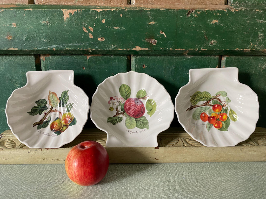 Three decorative ceramic plates with fruit designs