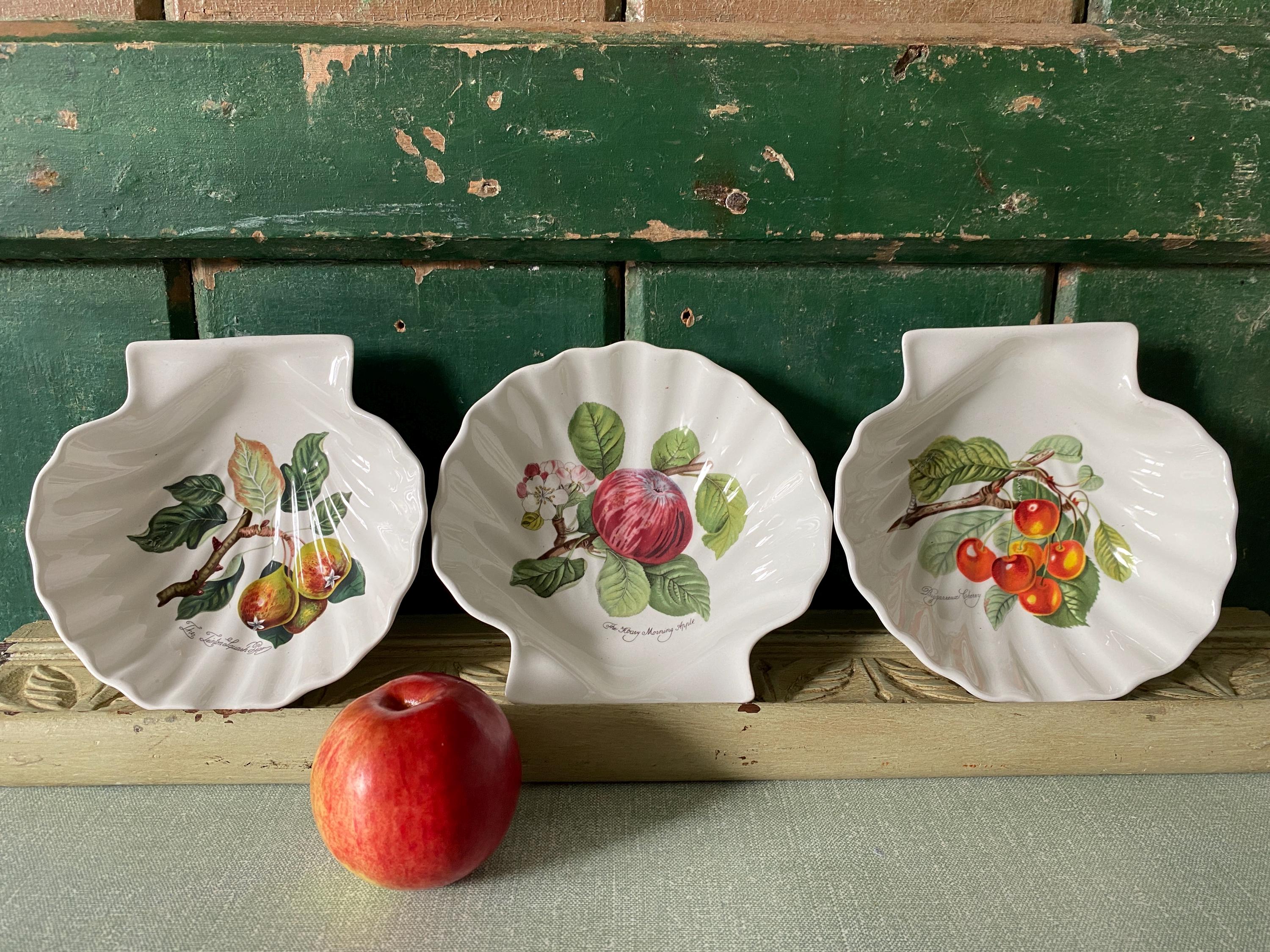 Three decorative ceramic plates with fruit designs