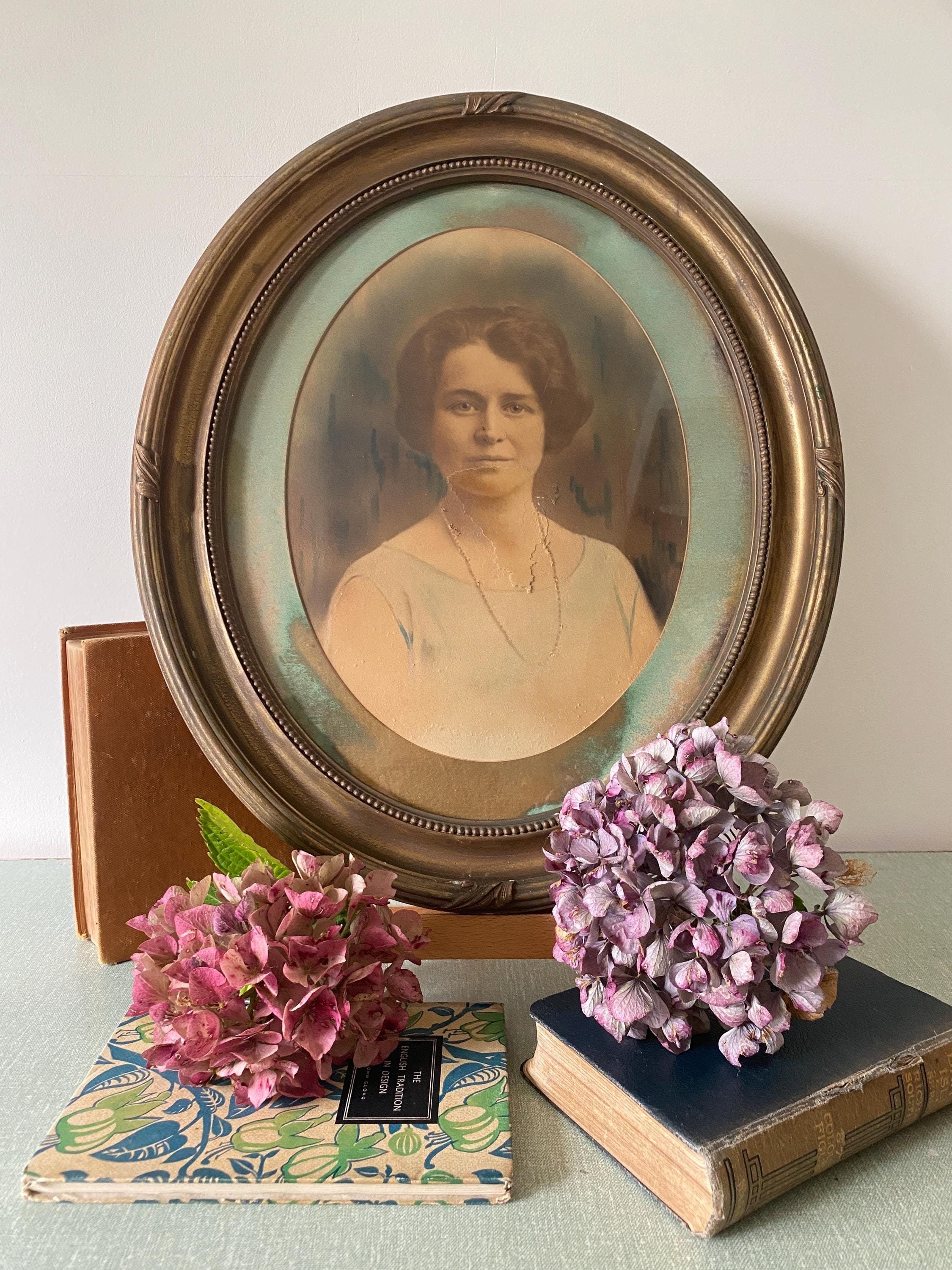 Vintage portrait of a woman in an oval gold frame