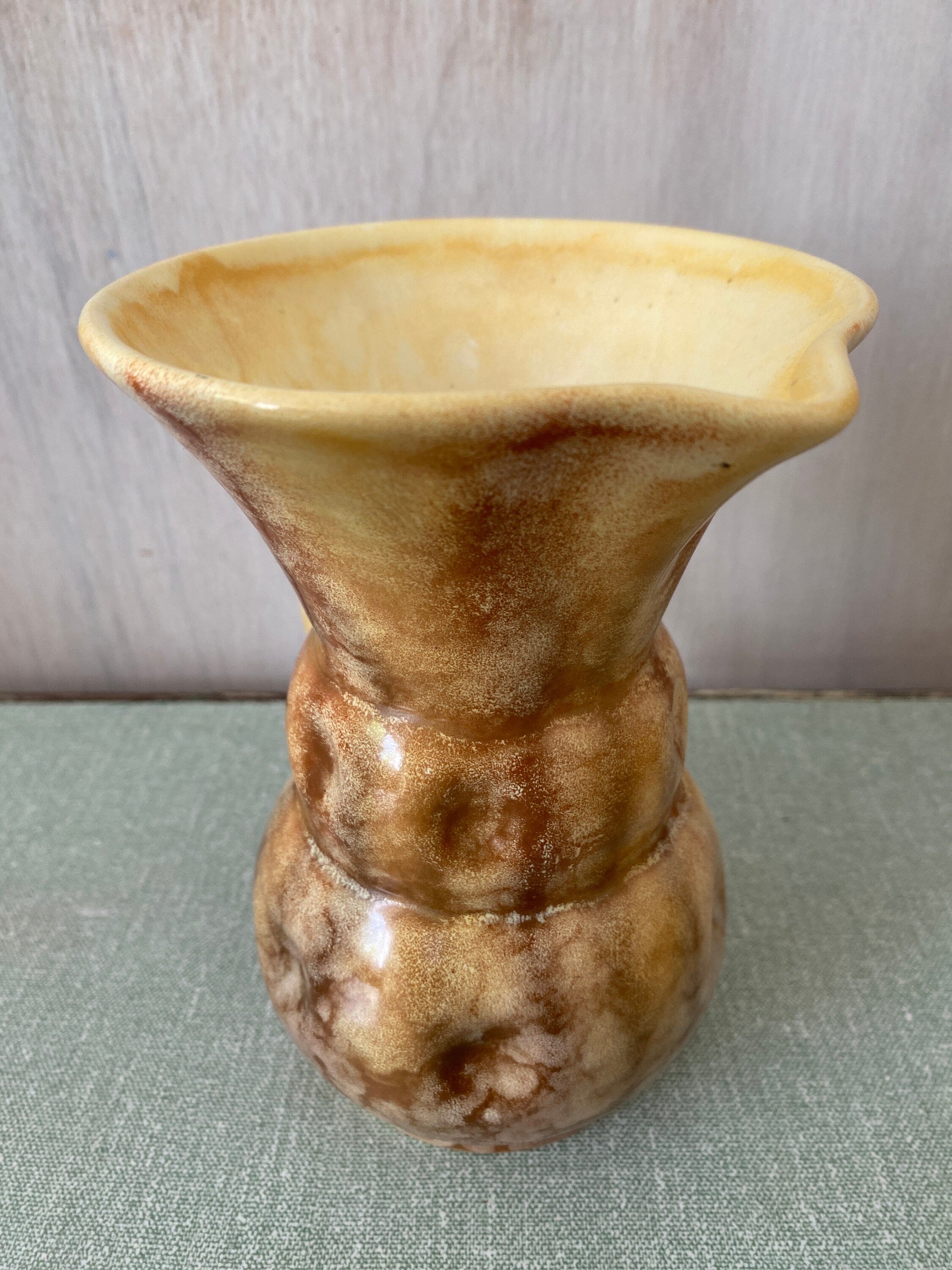 Top view of brown ceramic jug with cream interior and mottled glaze
