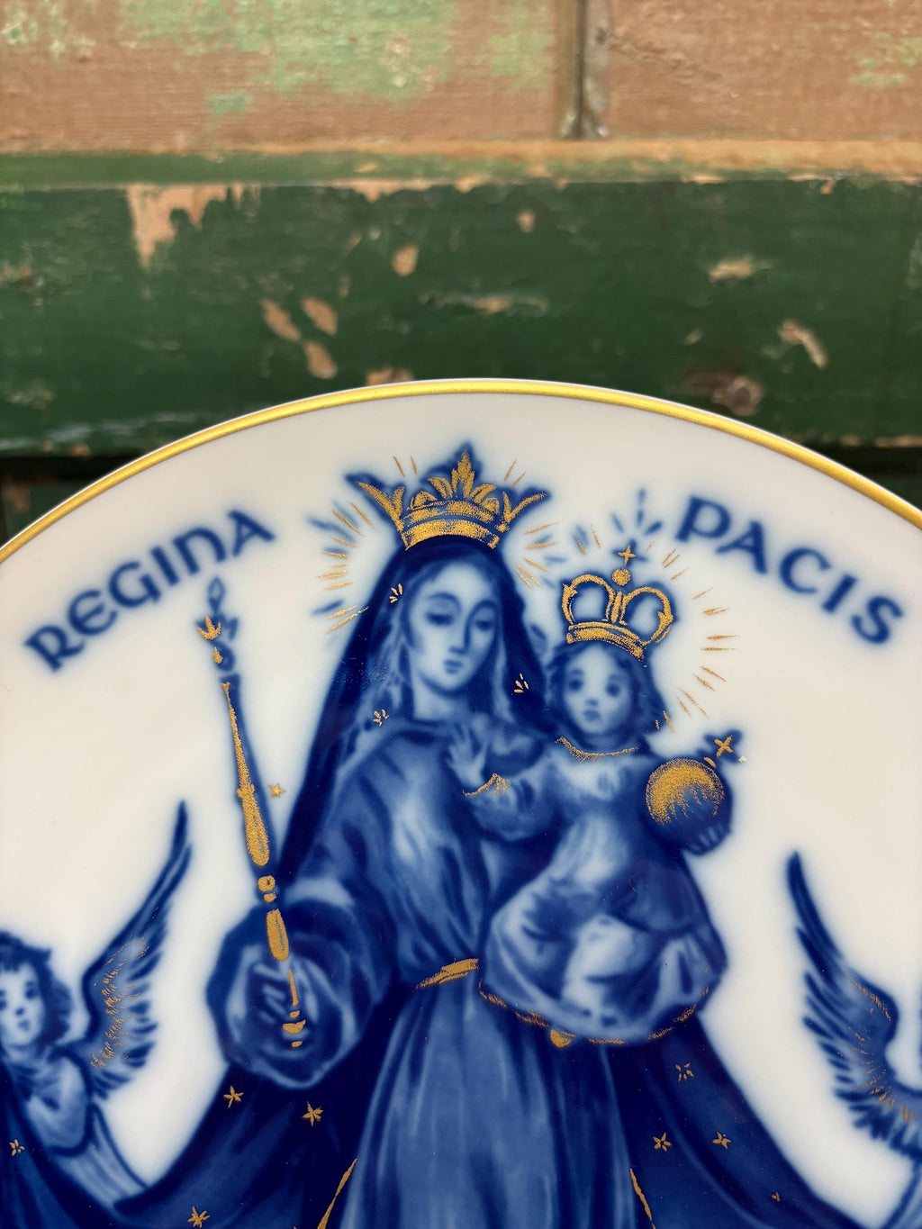 Decorative plate with blue and gold religious design featuring Mary cowned with angels and 'Regina Pacis' text