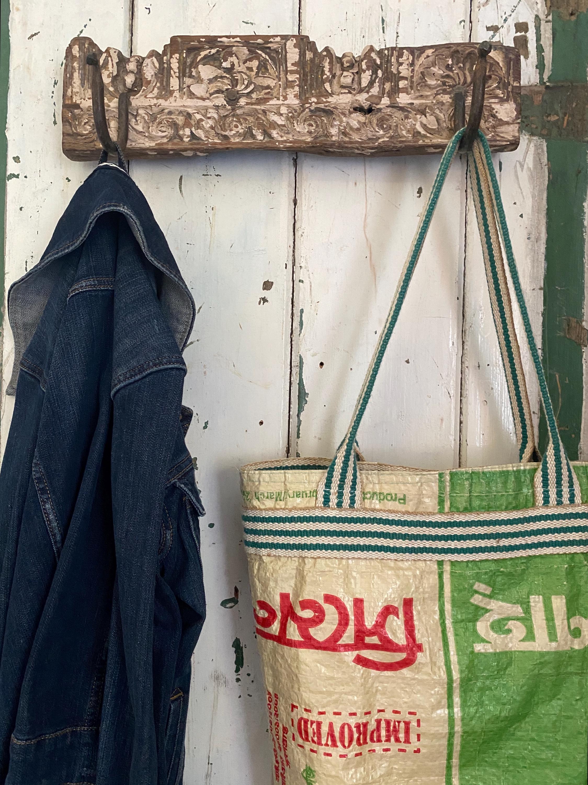 Vintage-style hook with a denim jacket and a green and beige tote bag 
