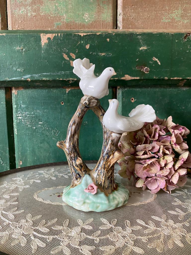 Decorative figurine of two white doves on a branch