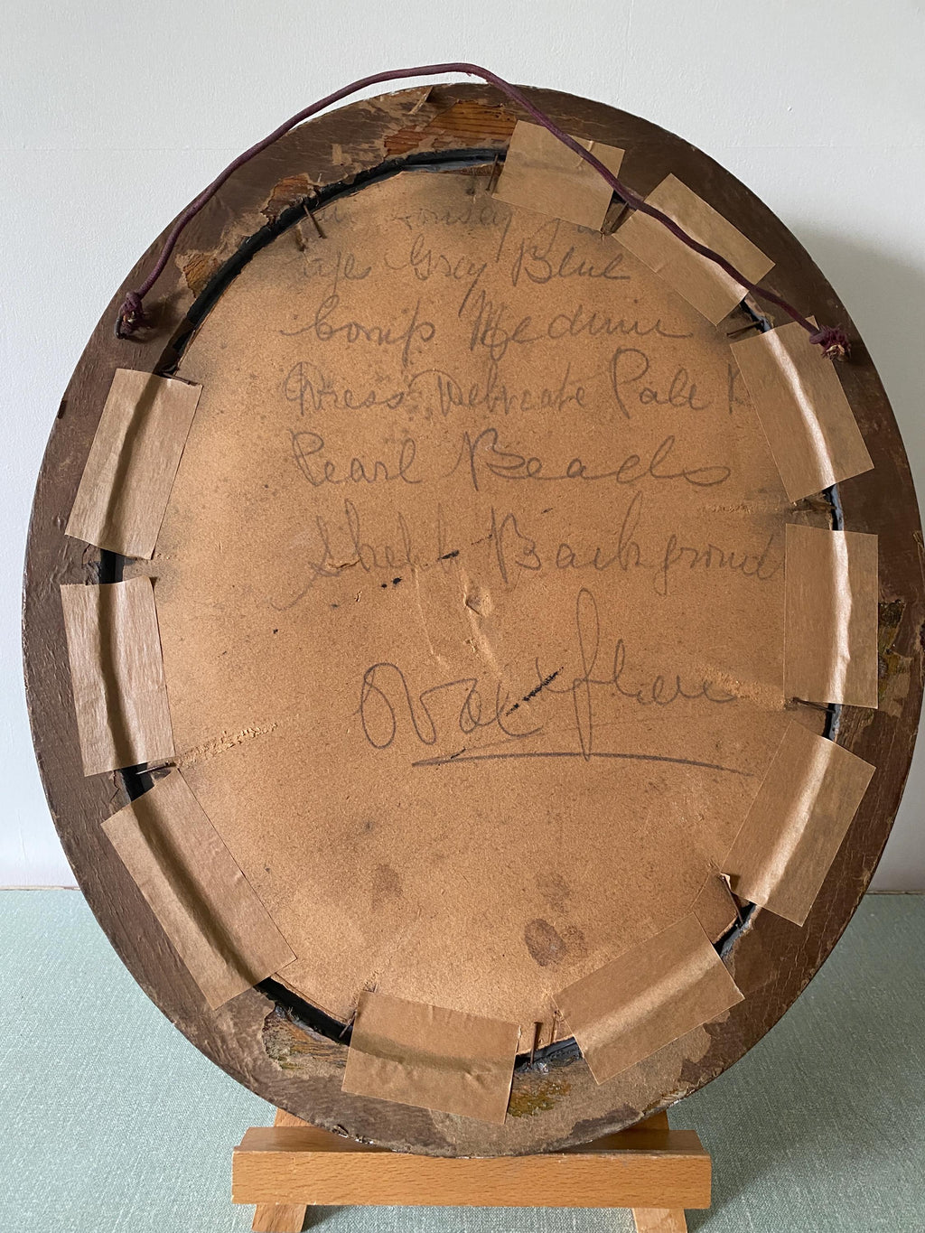 Back of a wooden oval picture frame with hand writing